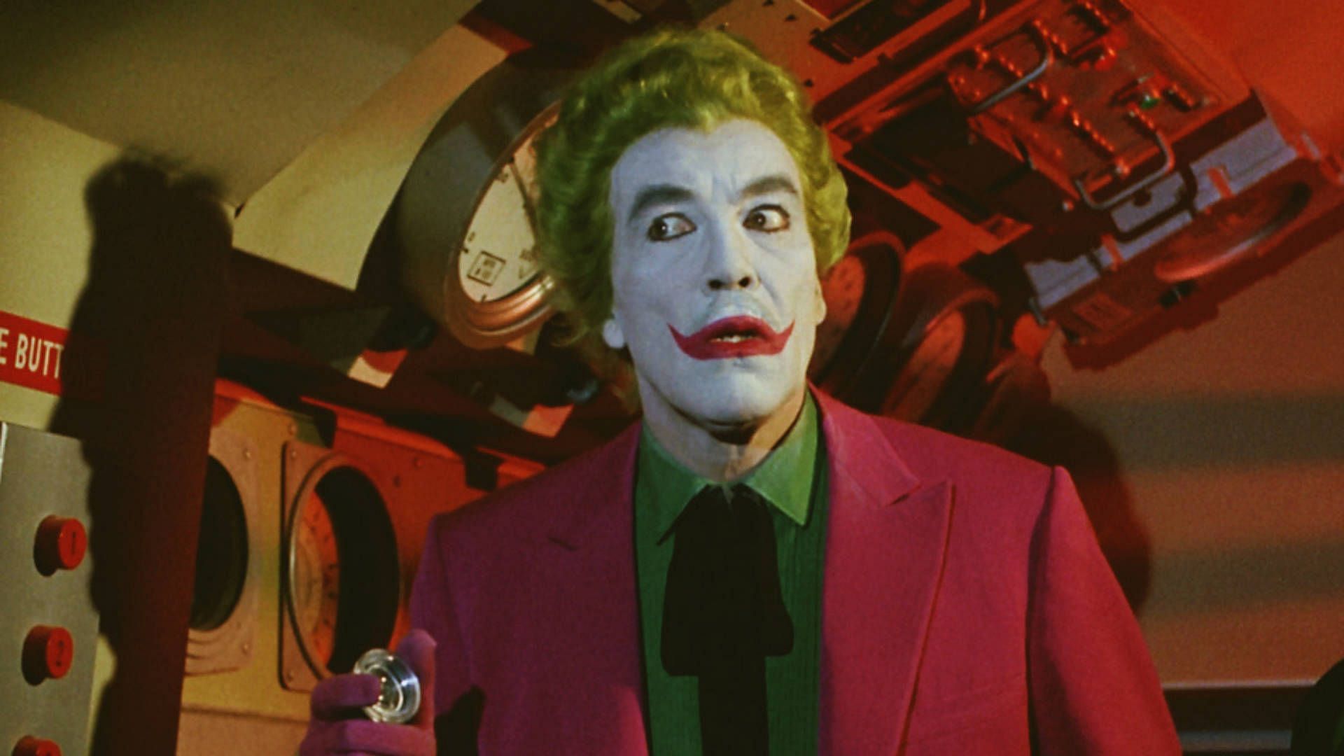 Romero&#039;s Joker was a colorful and flamboyant villain who wore a purple suit and white face paint with green hair. (Image via DC)