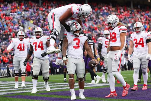 Miyan Williams #3 of the Ohio State Buckeyes celebrates with Paris Johnson Jr. #77 