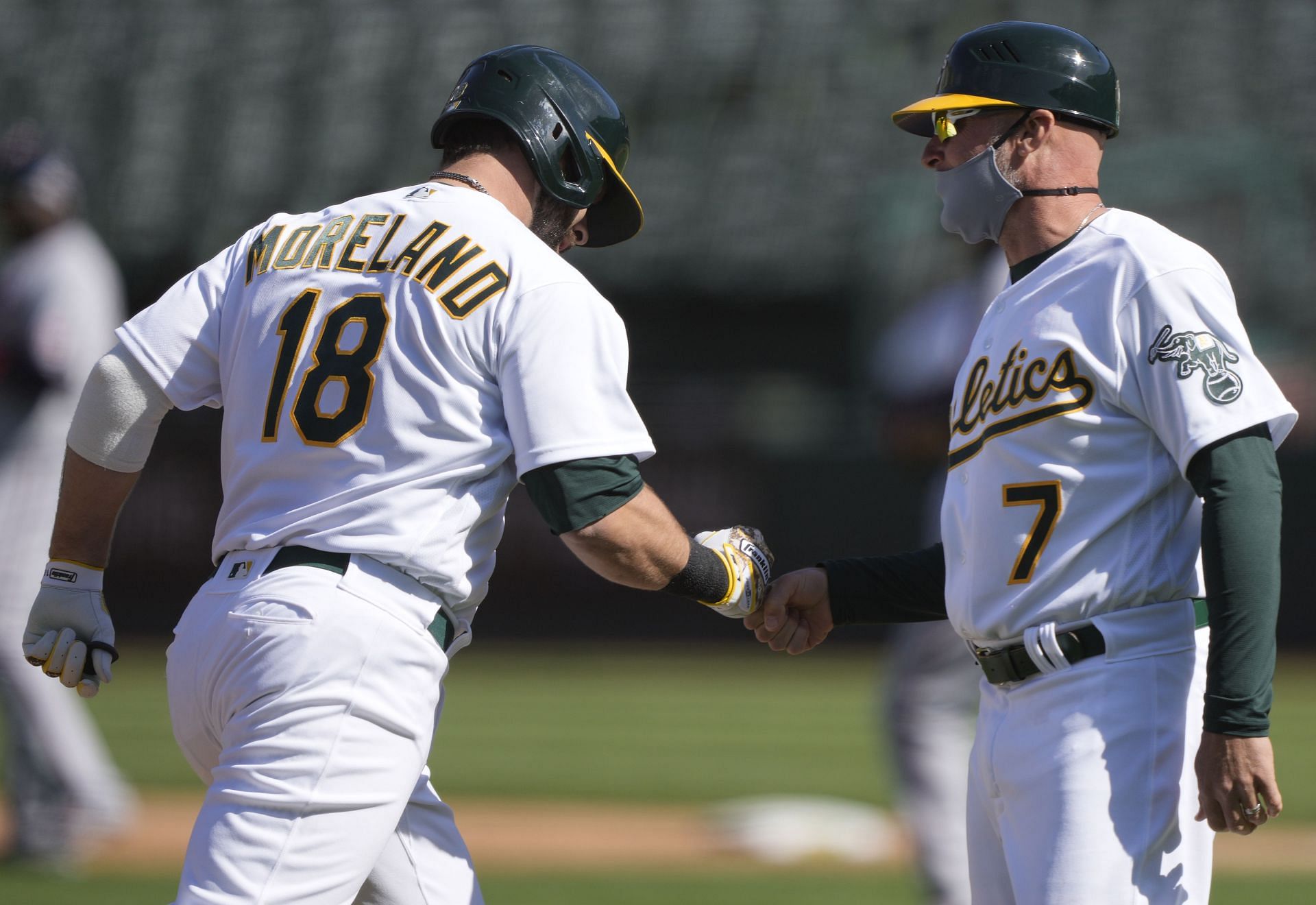 Mitch Moreland of the Oakland Athletics is congratulated by coach Mark Kotsay during a game at RingCentral Coliseum