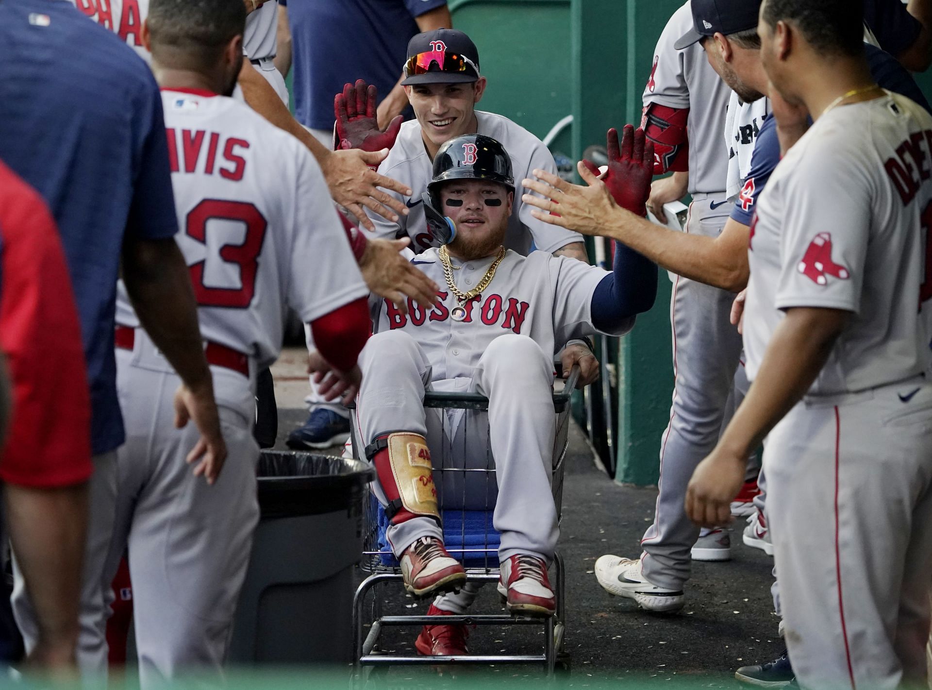 Alex Verdugo of the Boston Red Sox is pushed in a cart through the dug out by Jarren Duran against the Kansas City Royals