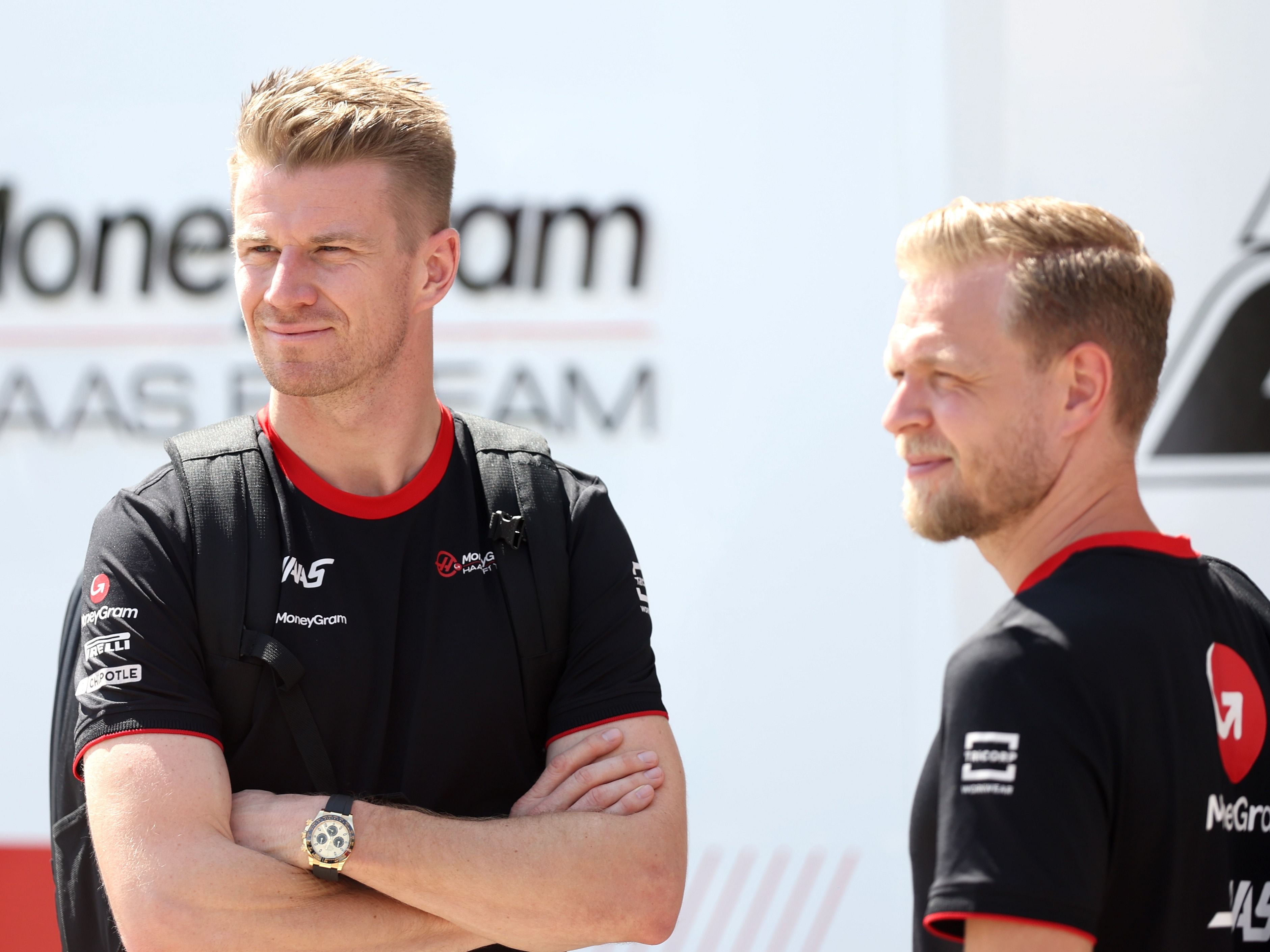 Kevin Magnussen and Nico Hulkenberg look on in the paddock during previews ahead of the 2023 F1 Bahrain Grand Prix. (Photo by Lars Baron/Getty Images)