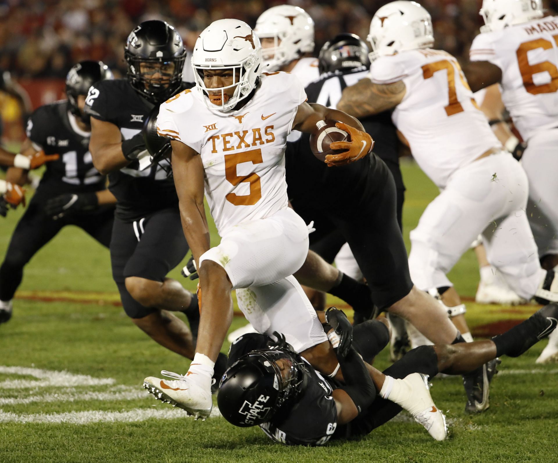 Running back Bijan Robinson #5 of the Texas Longhorns is tackled by defensive back Anthony Johnson Jr. #26