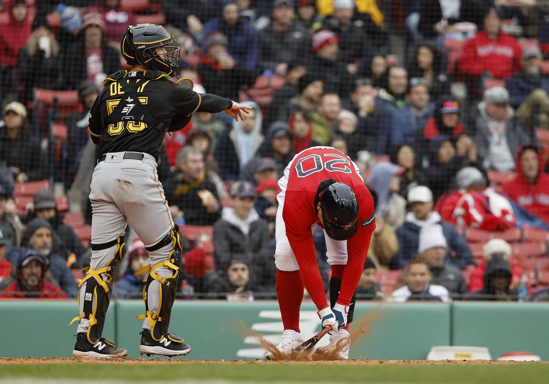 As catcher Jason Delay of the Pittsburgh Pirates throws the ball down to third, Yu Chang of the Boston Red Sox slams his bat into the dirt following a strikeout.