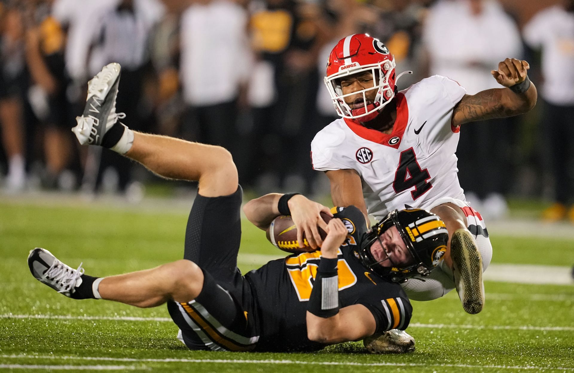 Brady Cook #12 of the Missouri Tigers is tackled by Nolan Smith #4 of the Georgia Bulldogs