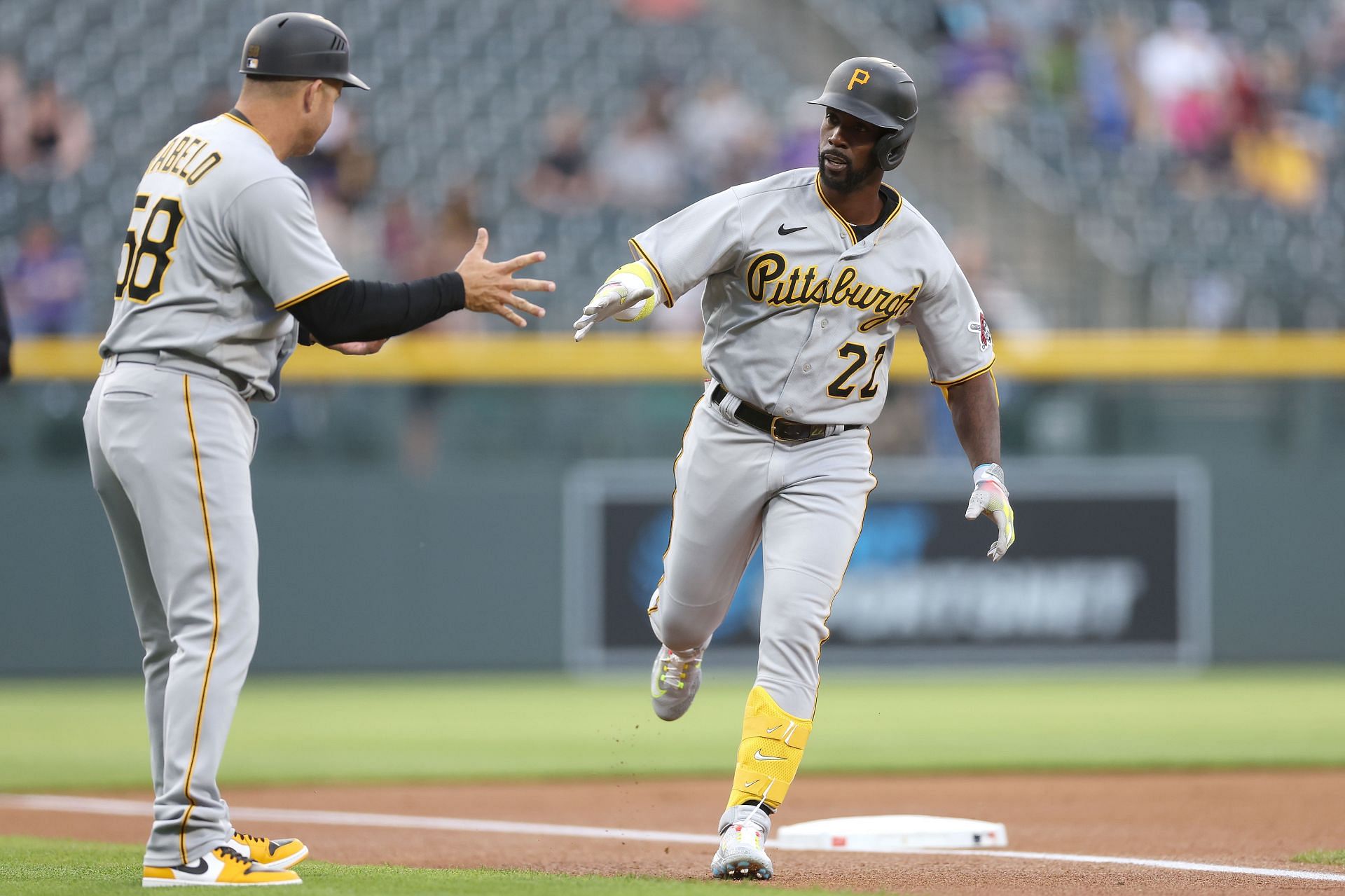 Andrew McCutchen of the Pittsburgh Pirates is congratulated by third base coach Mike Rabelo as he circles the bases after hitting a solo home run.