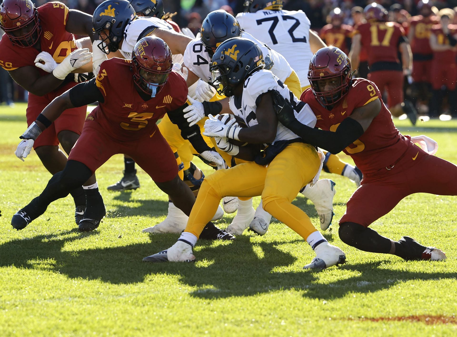 Running back Justin Johnson Jr. #26 of the West Virginia Mountaineers is tackled by defensive end Will McDonald IV #9 of the Iowa State Cyclones
