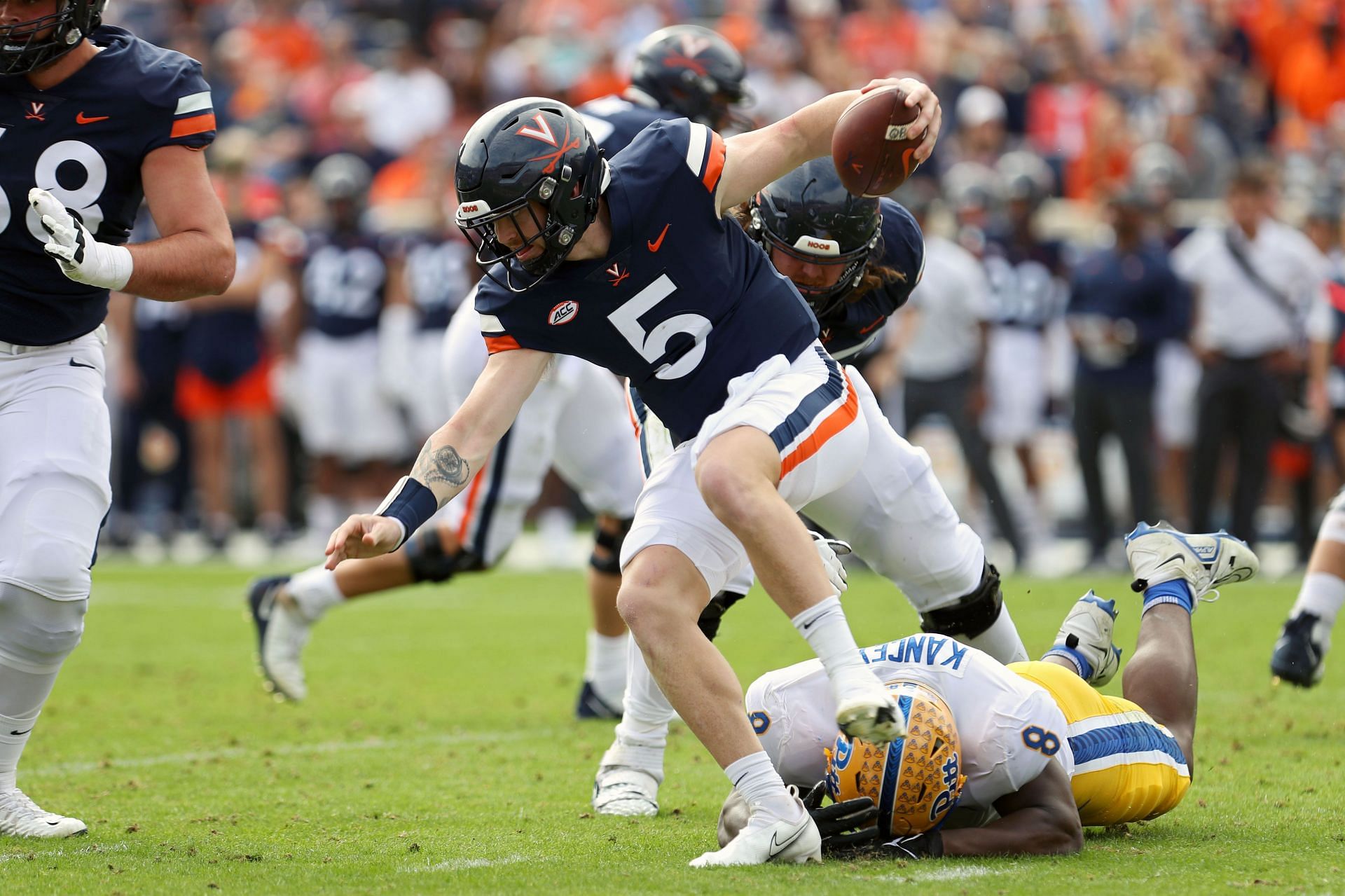 Calijah Kancey #8 of the Pittsburgh Panthers trips up Brennan Armstrong #5 of the Virginia Cavaliers