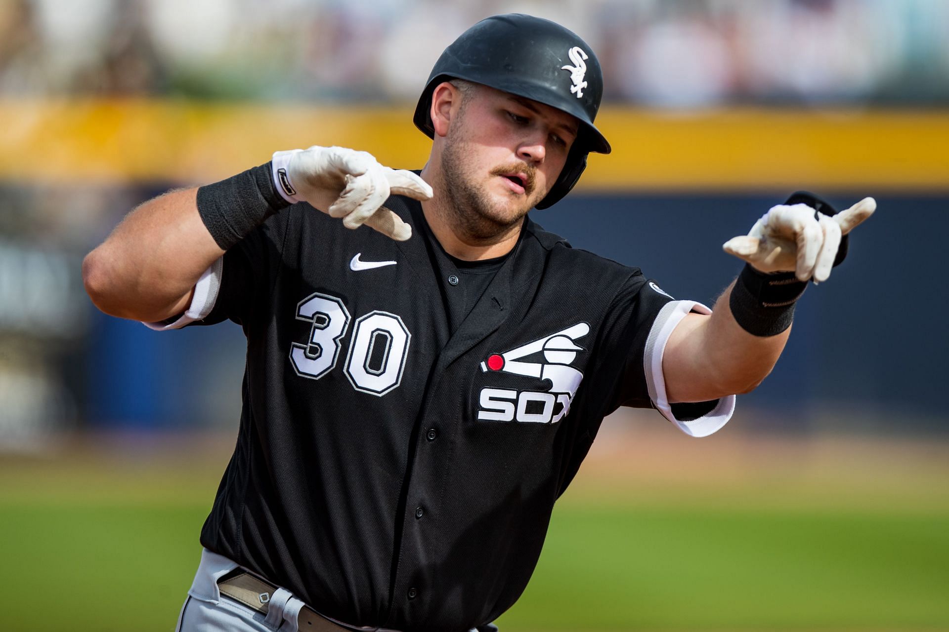 Jake Burger of the Chicago White Sox gestures while rounding the bases after hitting a home run.