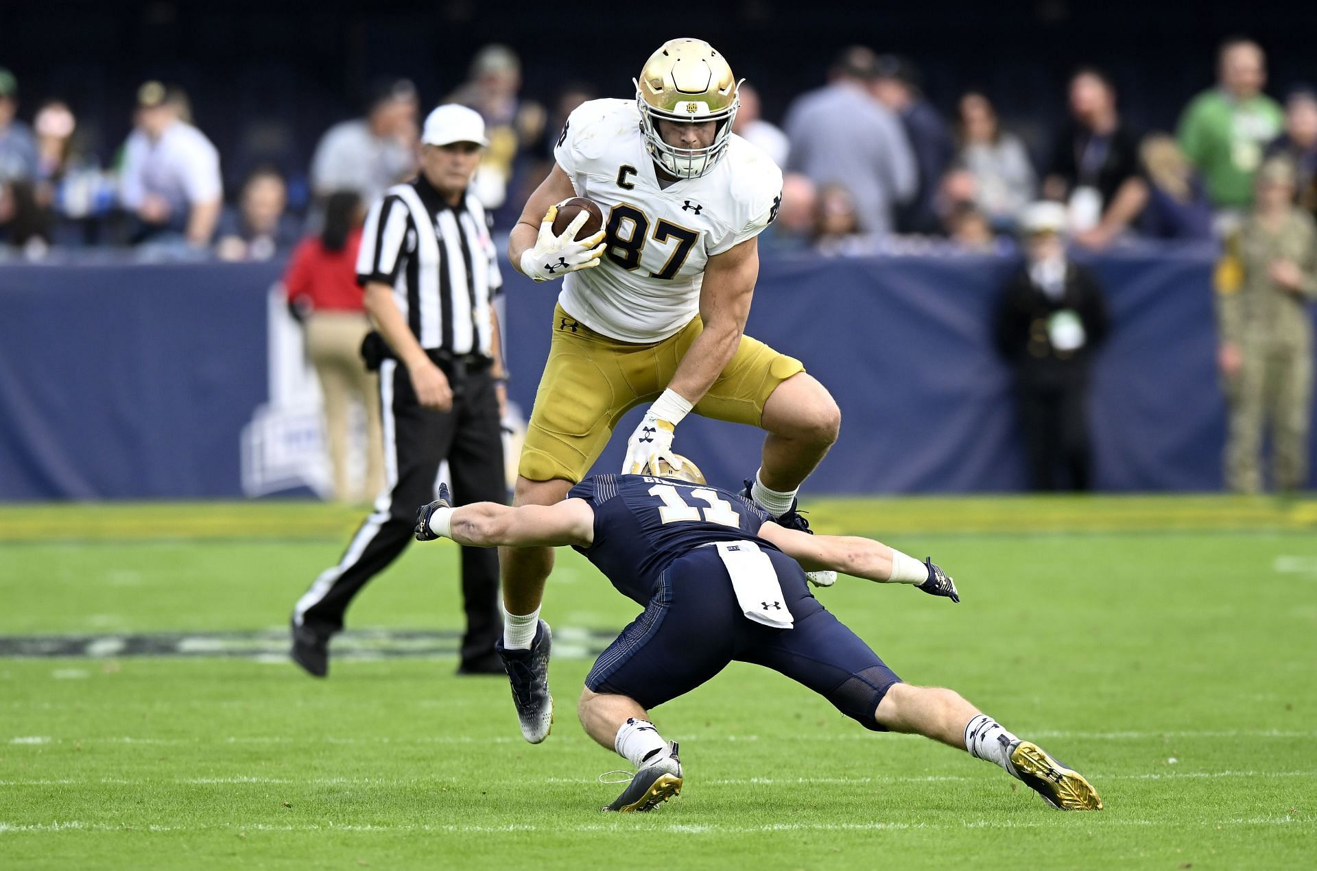 Michael Mayer #87 of the Notre Dame Fighting Irish jumps over Eavan Gibbons #11 of the Navy Midshipmen