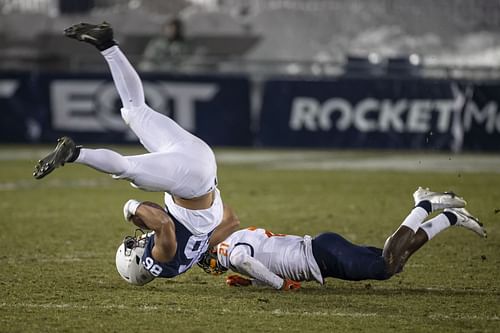 Brenton Strange #86 of the Penn State Nittany Lions is upended by Jartavius Martin #21 of the Illinois Fighting Illini