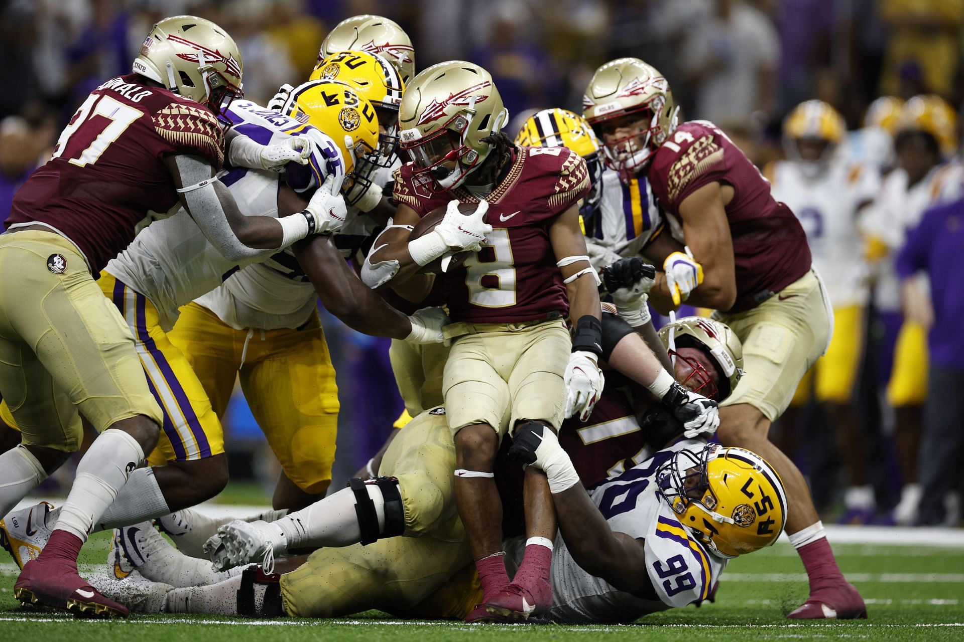 Running back Treshaun Ward #8 of the Florida State Seminoles is stopped by defensive tackle Jaquelin Roy #99 of the LSU Tigers 