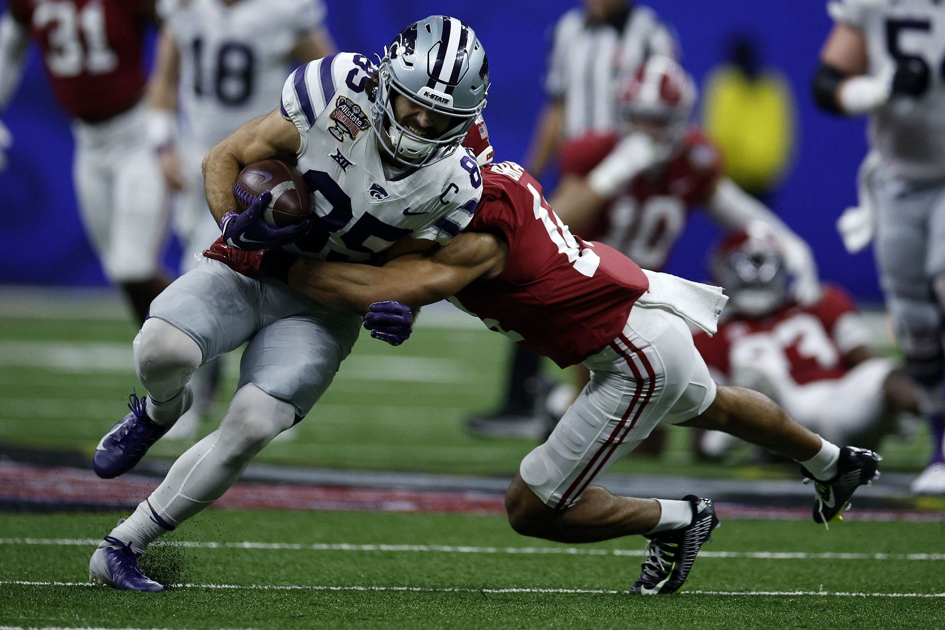 Will Swanson #83 of the Kansas State Wildcats is tackled by Brian Branch #14 of the Alabama Crimson Tide 