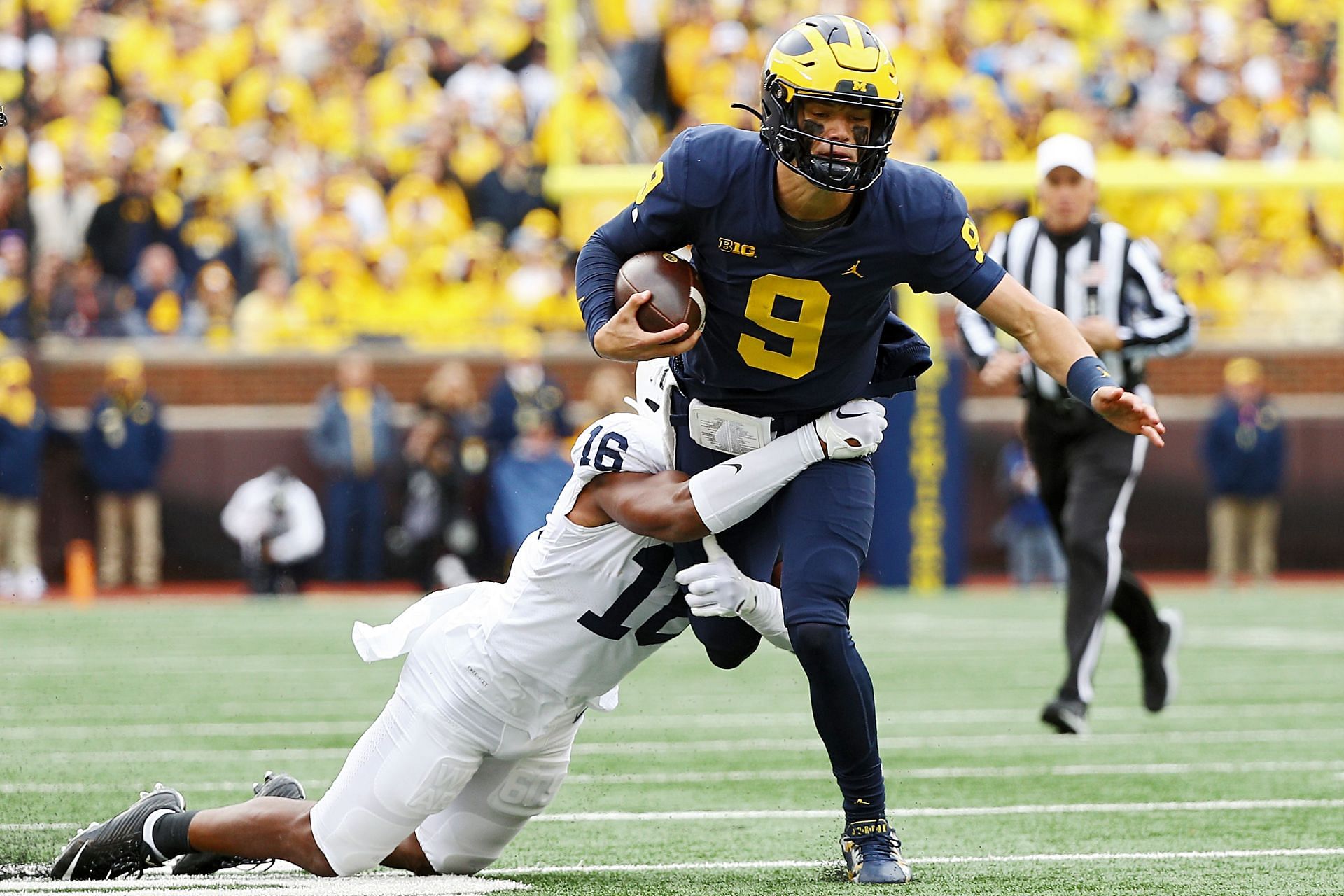 J.J. McCarthy #9 of the Michigan Wolverines is tackled by Ji&#039;Ayir Brown #16 of the Penn State Nittany Lions