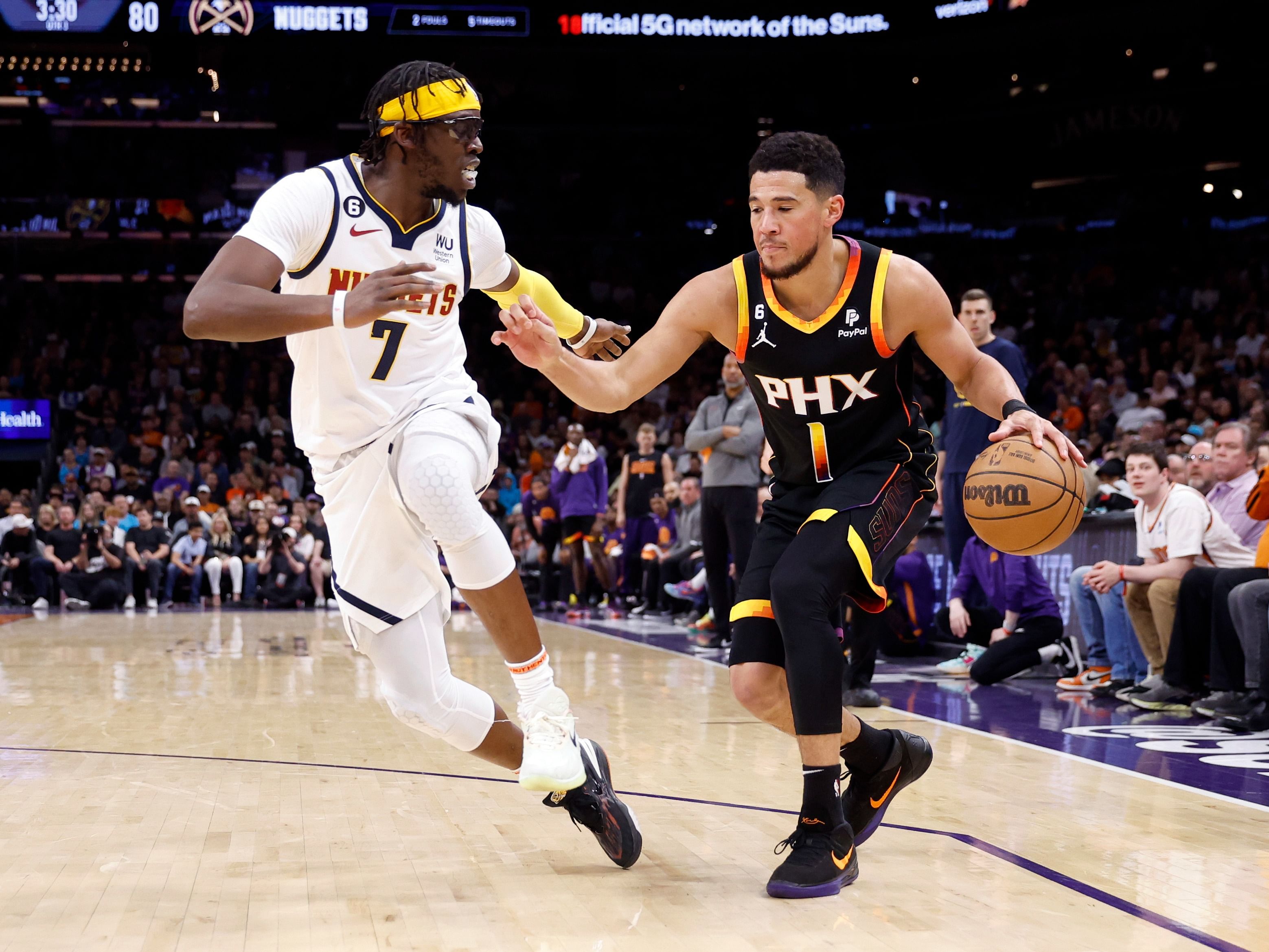 Reggie Jackson of the Denver Nuggets and Devin Booker of the Phoenix Suns