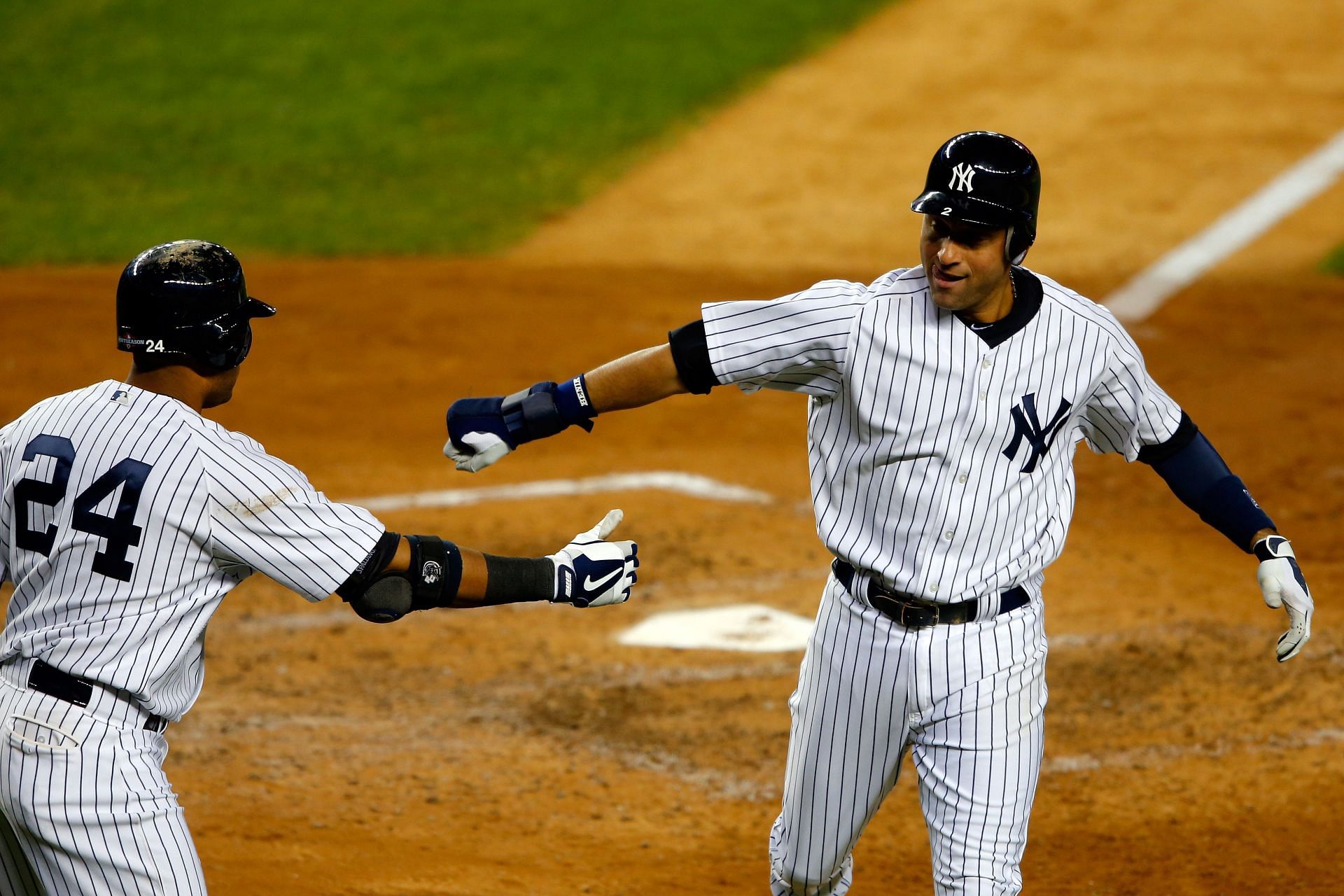 Derek Jeter of the New York Yankees celebrates with Robinson Cano #24 after scoring against the Baltimore Orioles at Yankee Stadium on October 12, 2012 in New York, New York. (Photo by Alex Trautwig/Getty Images)