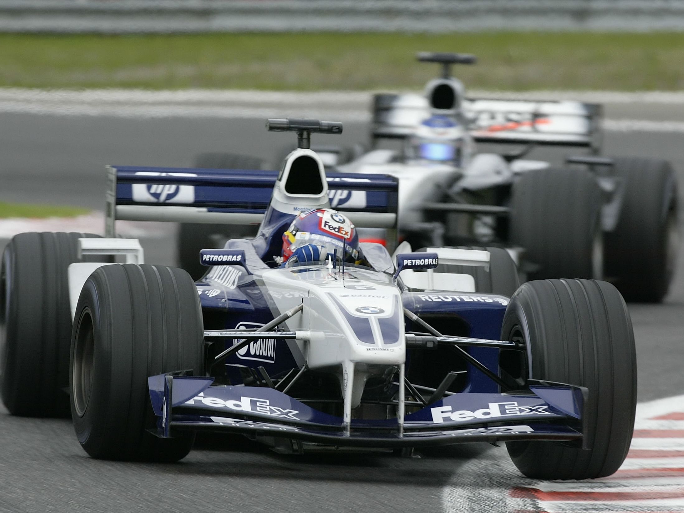 Juan Pablo Montoya is pursued by Kimi Raikkonen during the 2002 F1 Belgian Grand Prix (Photo by Clive Mason/Getty Images)