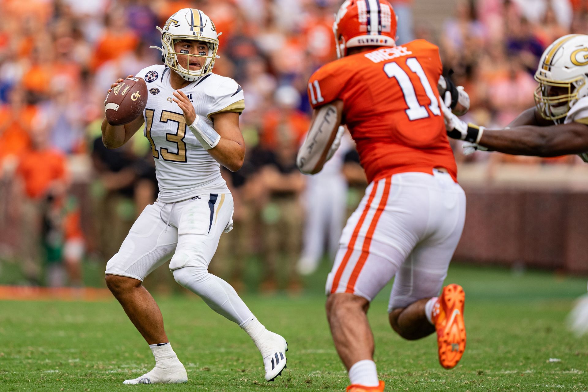 Quarterback Jordan Yates #13 of the Georgia Tech Yellow Jackets is pressured by defensive lineman Bryan Bresee #11 of the Clemson Tigers
