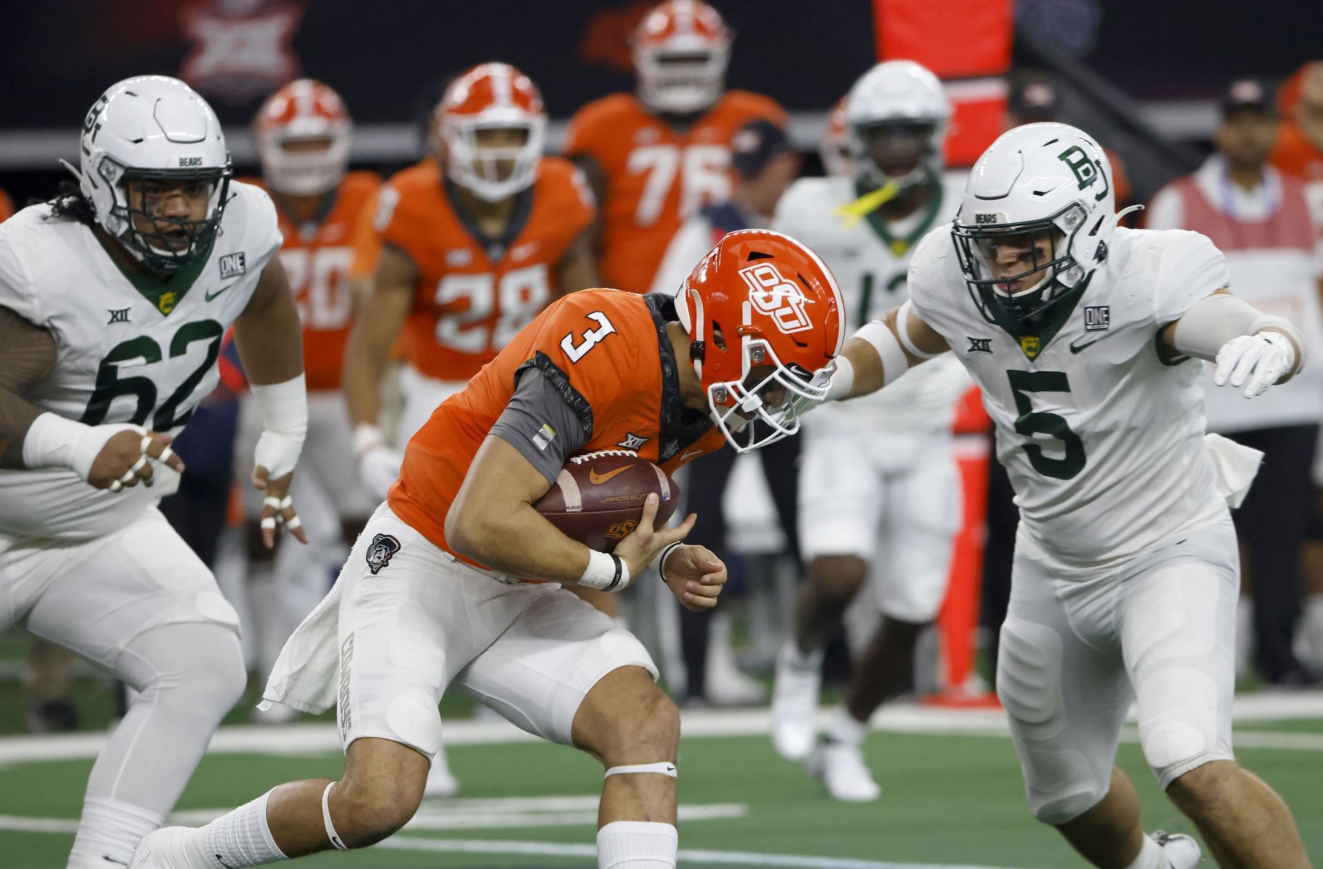 Spencer Sanders #3 of the Oklahoma State Cowboys is met by Dillon Doyle #5 and Siaki Ika #62 of the Baylor Bear