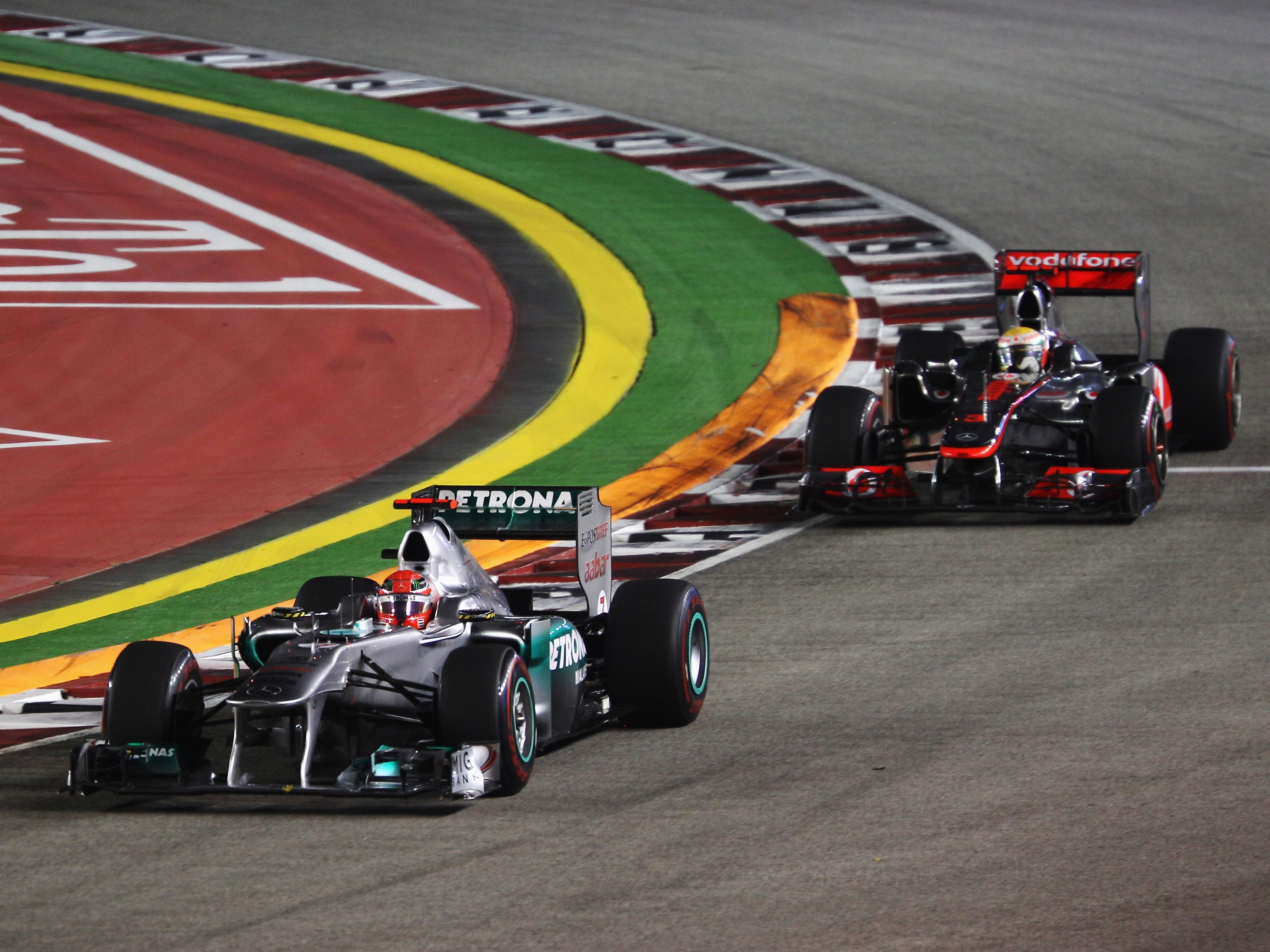 Michael Schumacher leads from Lewis Hamilton before crashing out during the 2011 F1 Singapore Grand Prix (Photo by Mark Thompson/Getty Images)