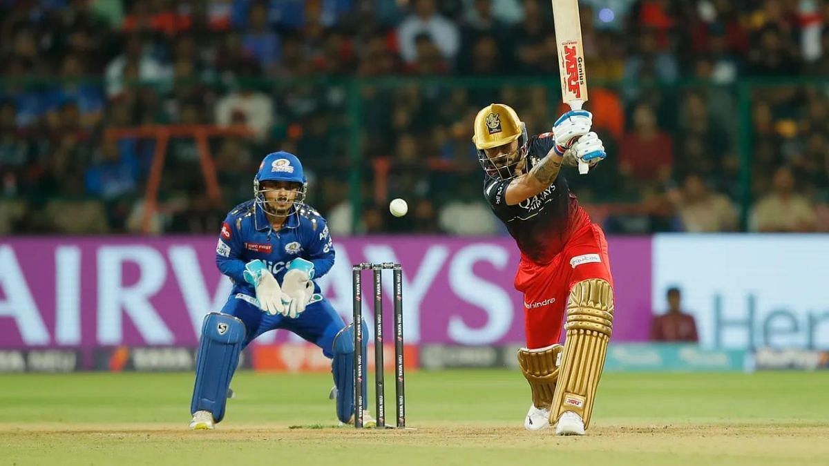 MI keeper Ishan Kishan looks on as Virat Kohli plays a shot. Courtesy: IPL