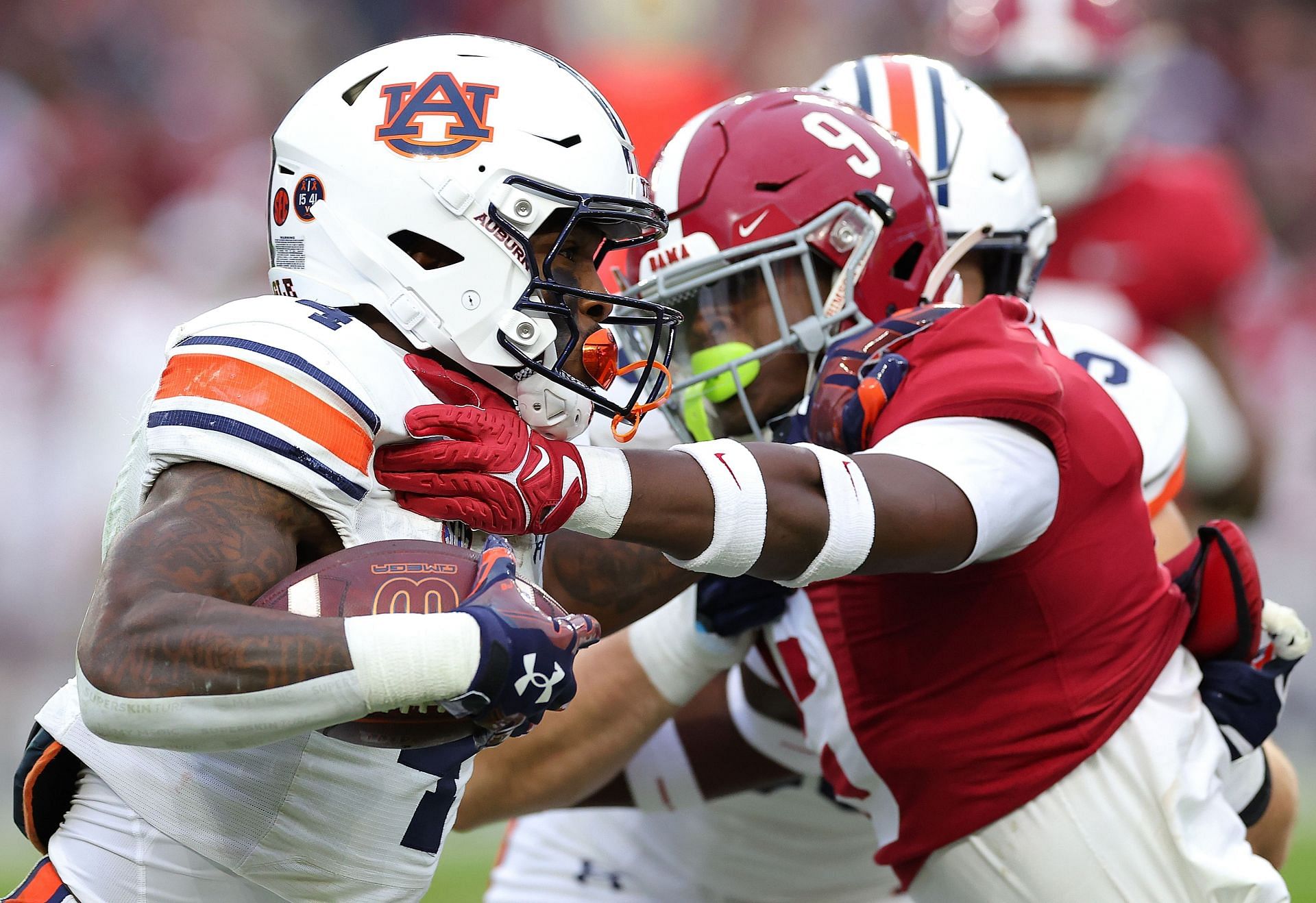 Tank Bigsby #4 of the Auburn Tigers rushes against Jordan Battle #9 of the Alabama Crimson Tide 