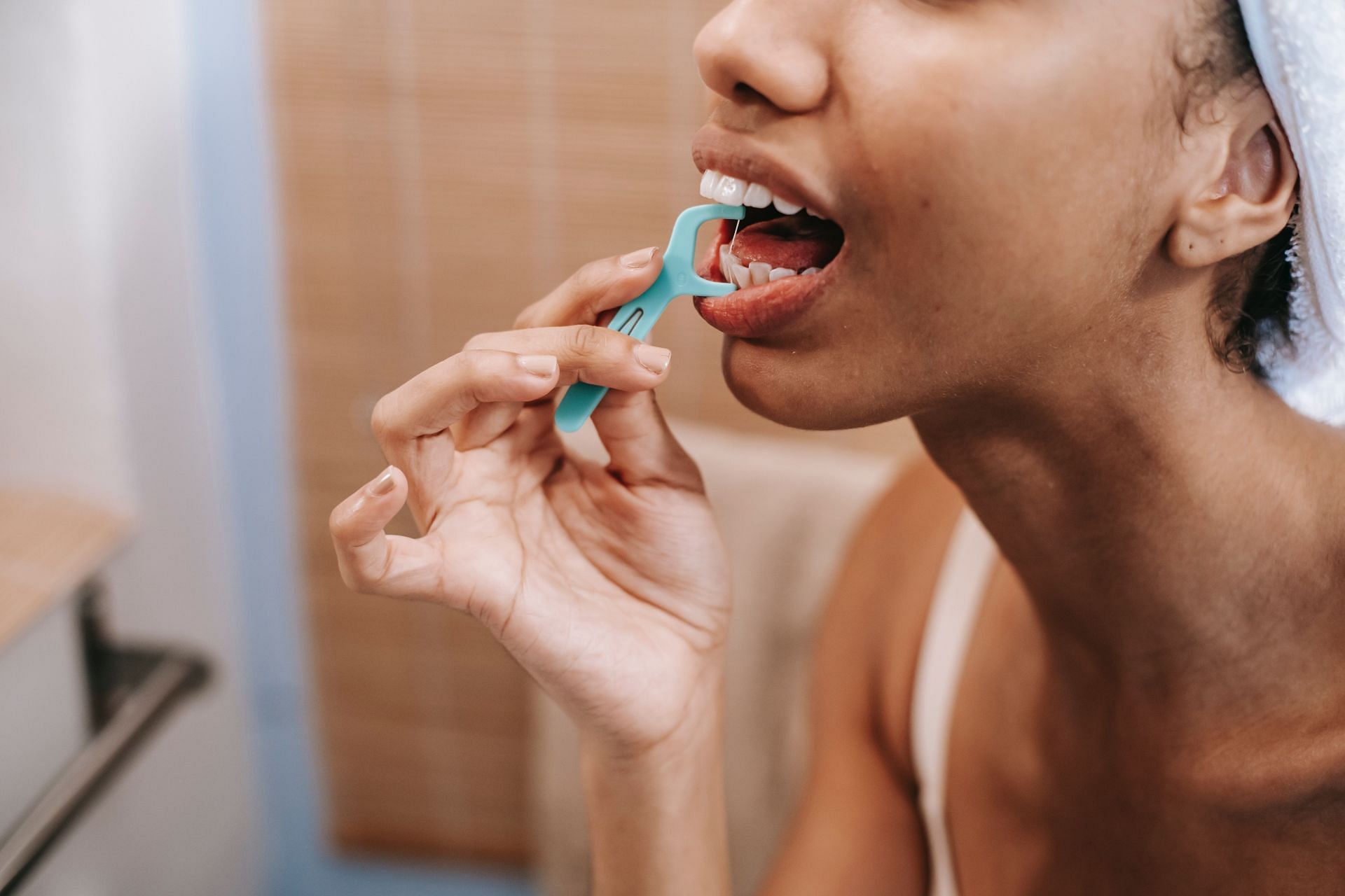 Use a fresh section of floss for each tooth to avoid transferring bacteria between tooth. (Image via Pexels)