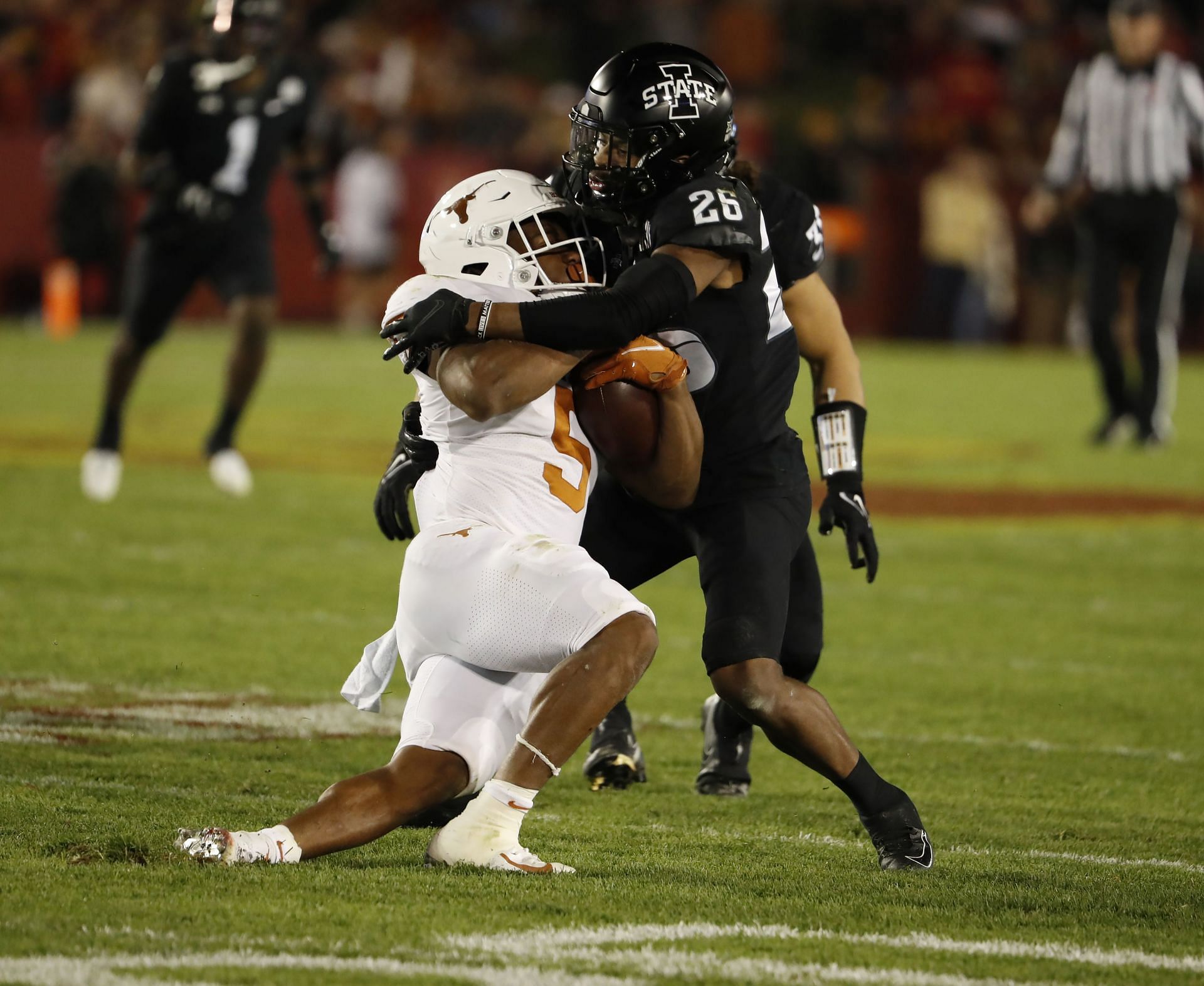 Defensive back Anthony Johnson Jr. #26 of the Iowa State Cyclones tackles running back Bijan Robinson #5 of the Texas Longhorns