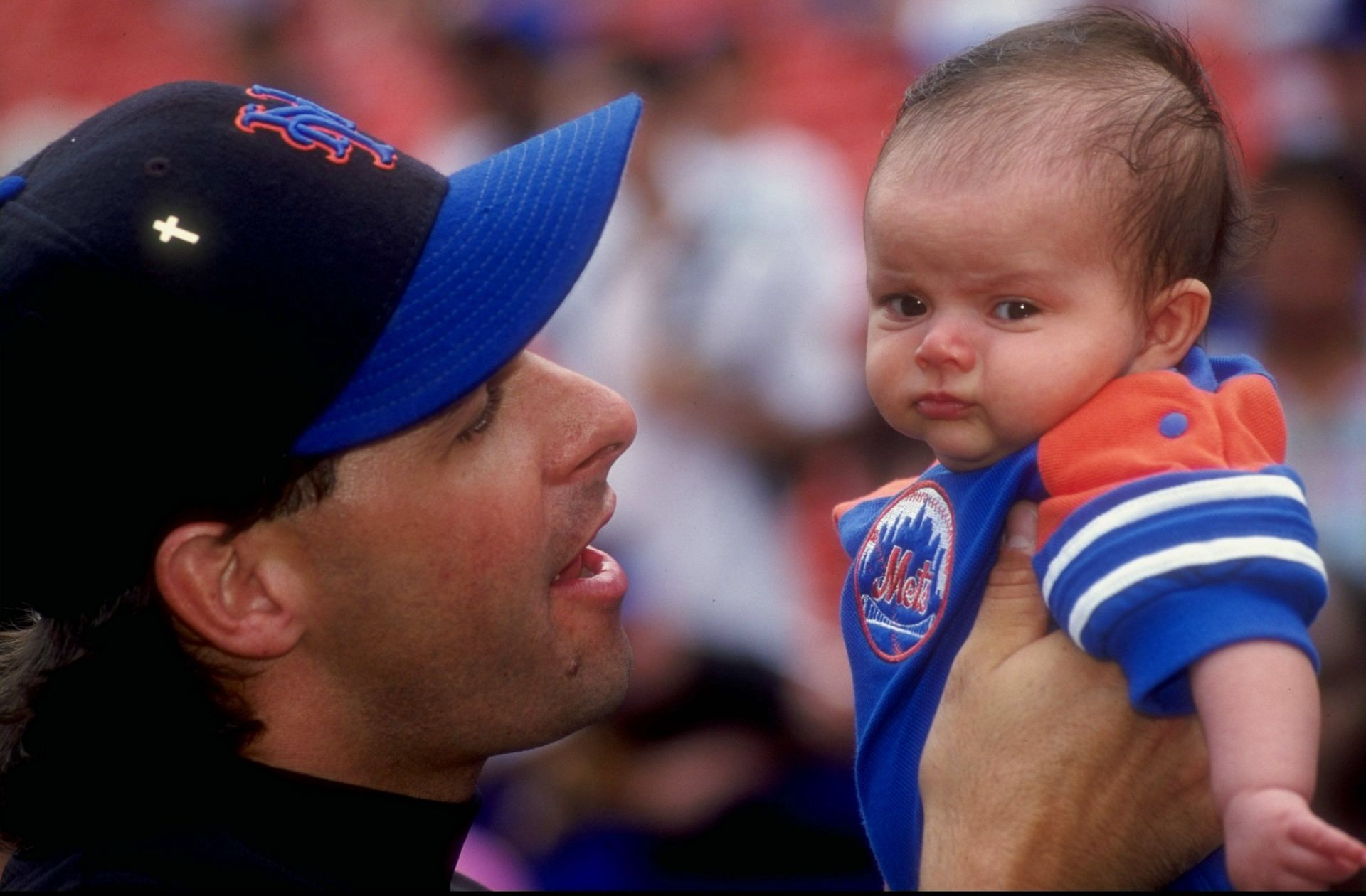 Pitcher Turk Wendell #99 of the New York Mets holds a baby prior to a game