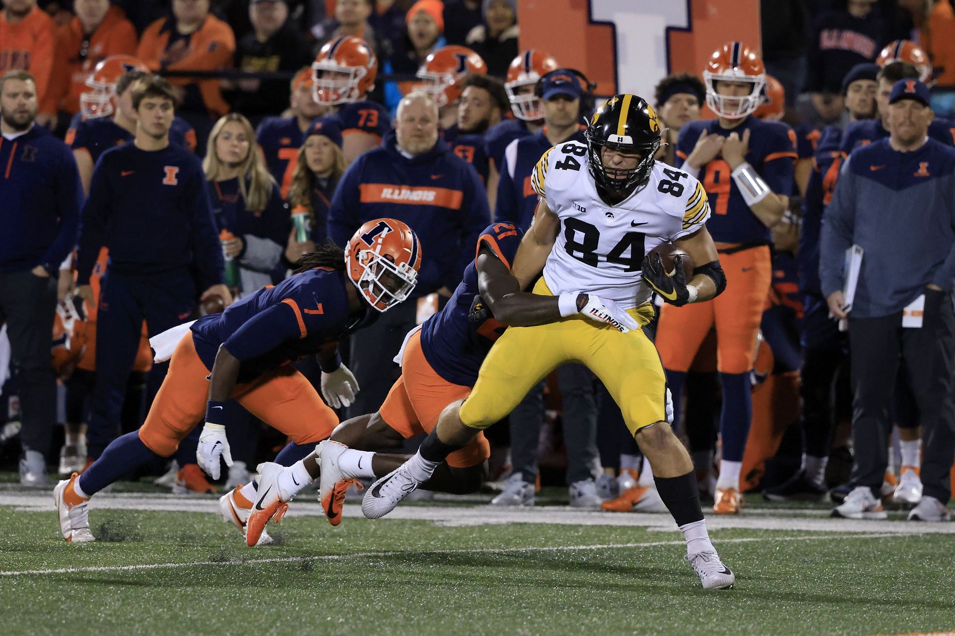 Sam LaPorta #84 of the Iowa Hawkeyes is tackled by Jartavius Martin #21 and Kendall Smith #7 of the Illinois Fighting Illini 