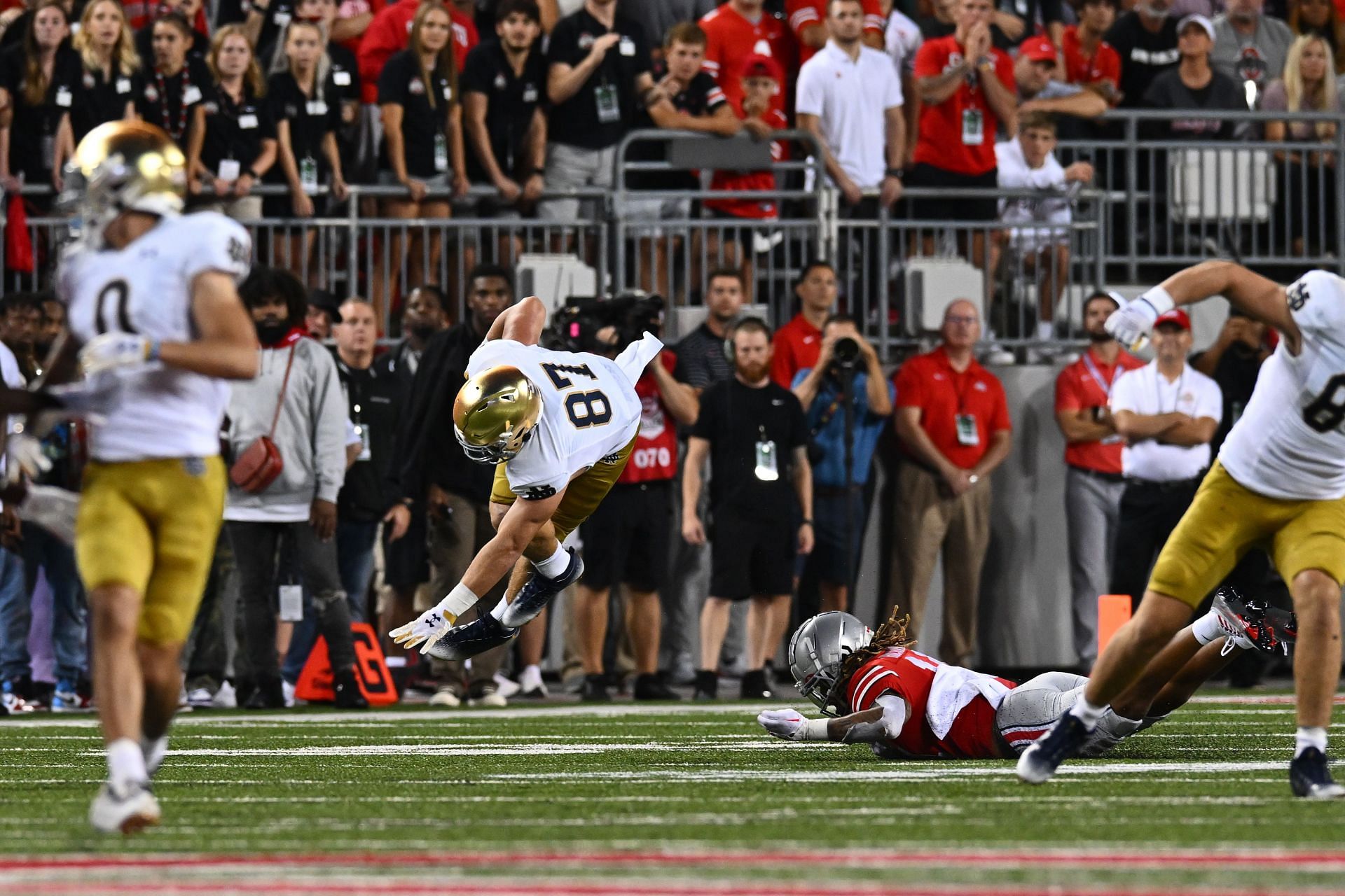 Michael Mayer #87 of the Notre Dame Fighting Irish is upended by Ronnie Hickman #14 of the Ohio State Buckeyes