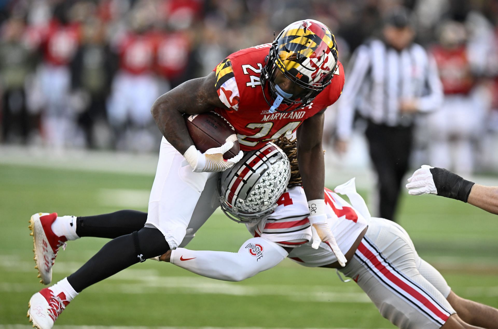 Roman Hemby #24 of the Maryland Terrapins is tackled by Ronnie Hickman #14 of the Ohio State Buckeyes