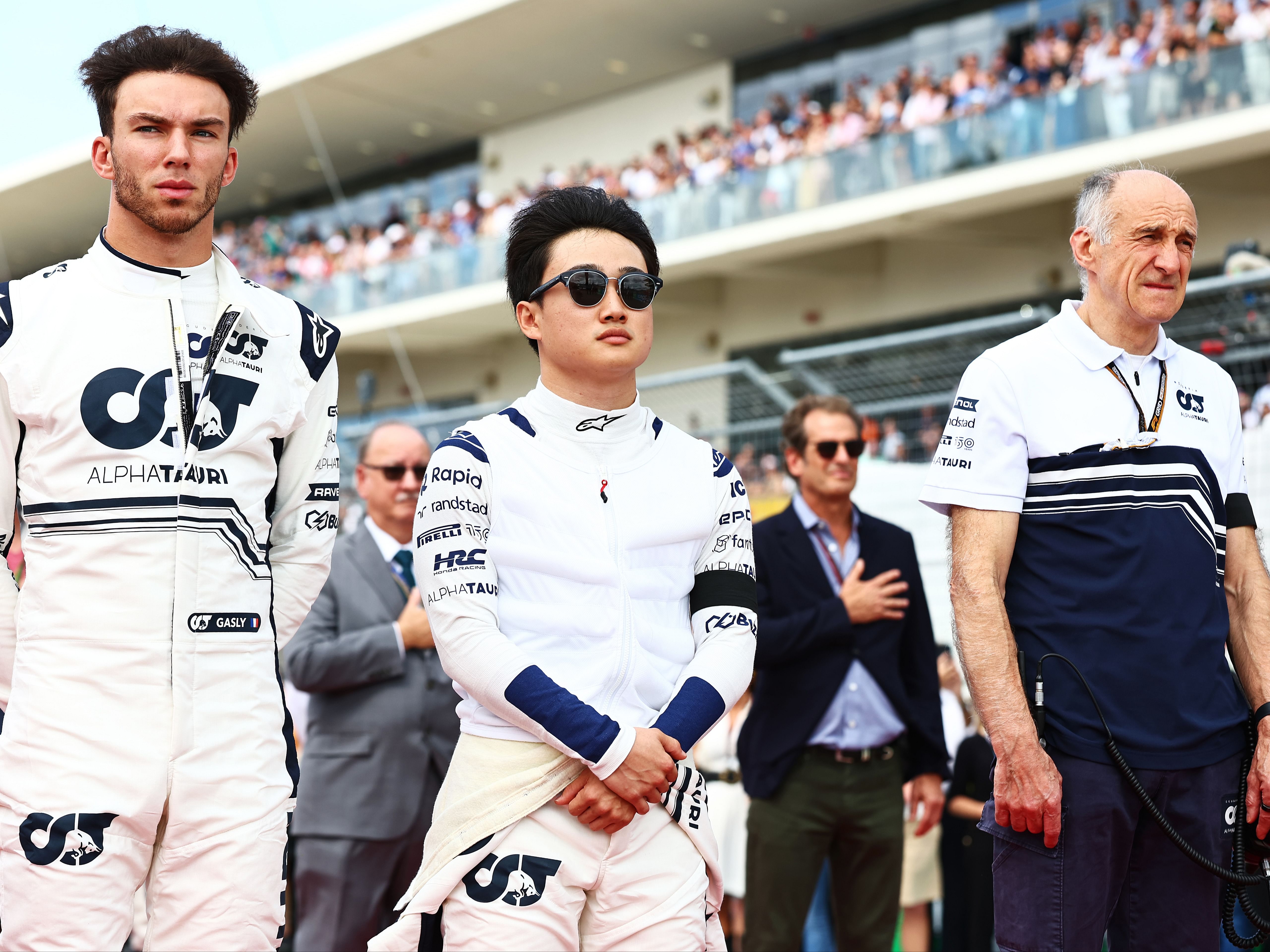 Pierre Gasly, Yuki Tsunoda and Franz Tost stand in tribute to the late Dietrich Mateschitz on the grid during the 2022 F1 USA Grand Prix. (Photo by Mark Thompson/Getty Images)