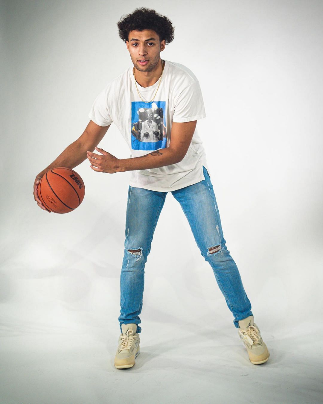 Anton Watson poses with a basketball in his hands. Via Instagram