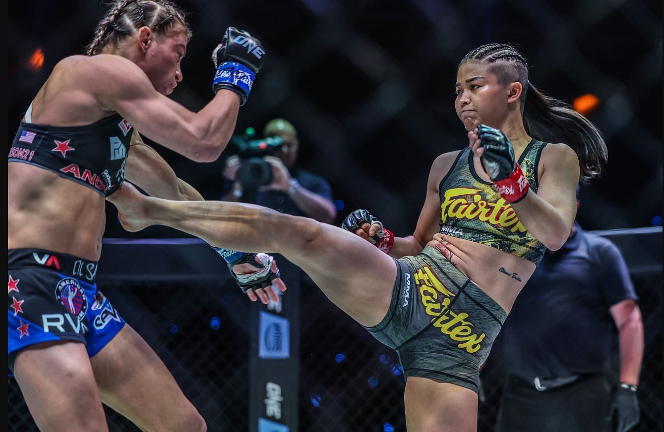 Alyse Anderson (L) winced in agony and dropped to the canvas after receiving this brutal body kick from Stamp Fairtex (R)