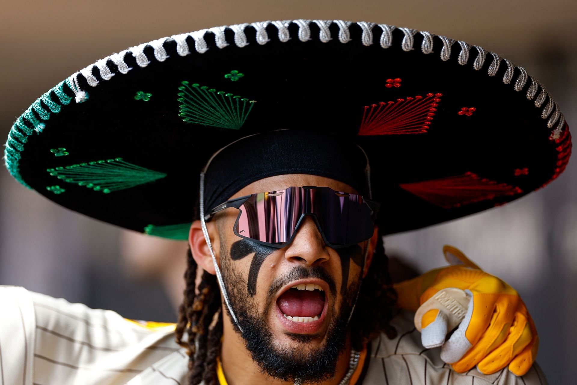Fernando Tatis Jr. celebrates his home run while wearing a celebratory sombrero in the dugout against the Minnesota Twins at Target Field
