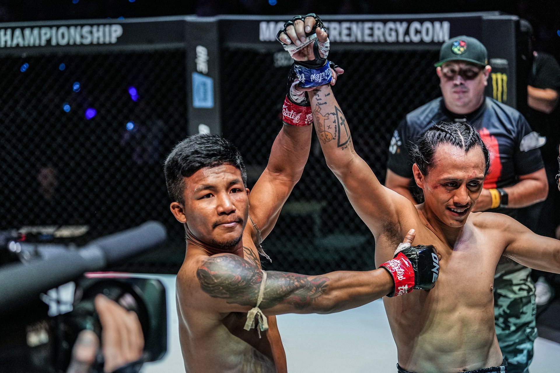 Rodtang (L) shows the grace of a true world champion by raising Edgar Tabares&rsquo; (R) hand after their hard-fought match