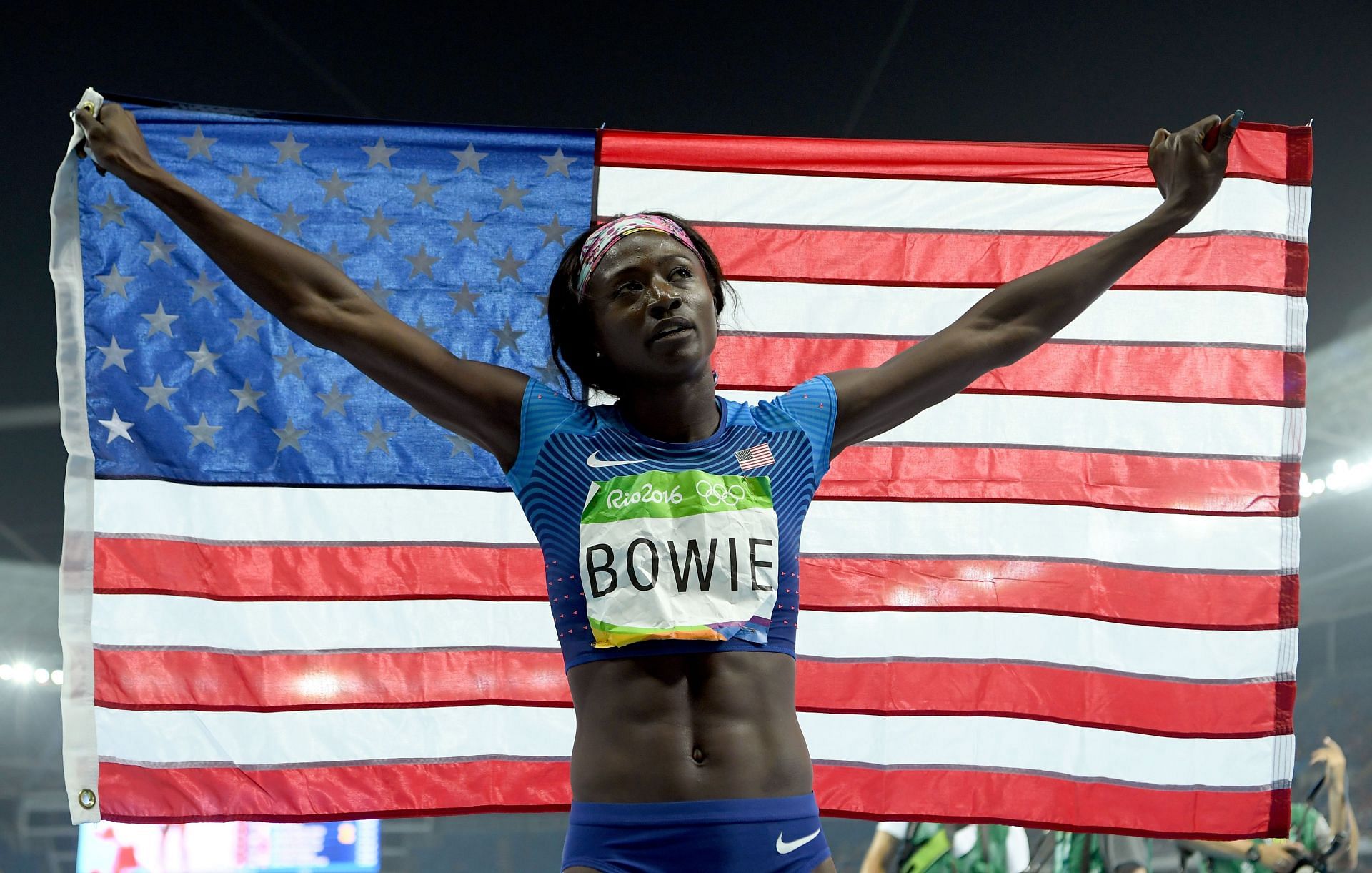 Tori Bowie of the United States celebrates with the American flag after winning the bronze medal in the Women&#039;s 200m Final on Day 12 of the Rio 2016 Olympic Games