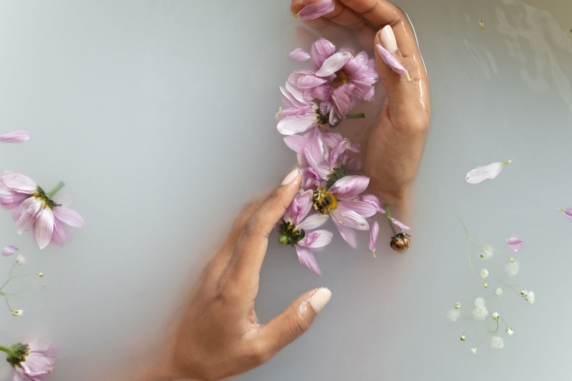 Soaking hands in warm water is one of the ways to get rid of cracked hands and feet (Image via Pexels)