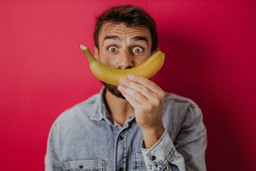 Young man eating healthy bananas(Image via getty Images)
