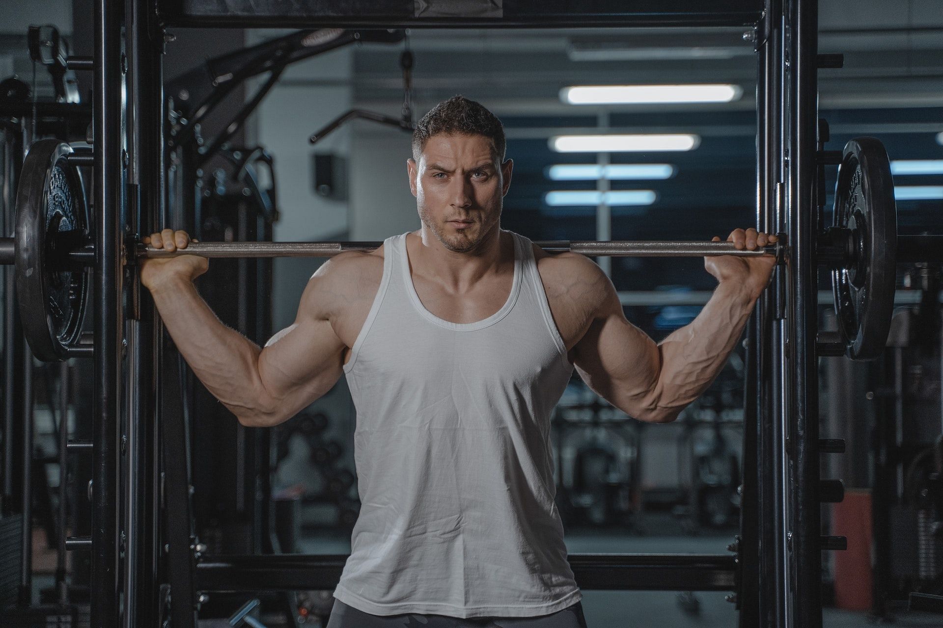 Curls with bar targets the biceps, triceps, shoulders, and back. (Photo via Pexels/Tima Miroshnichenko)