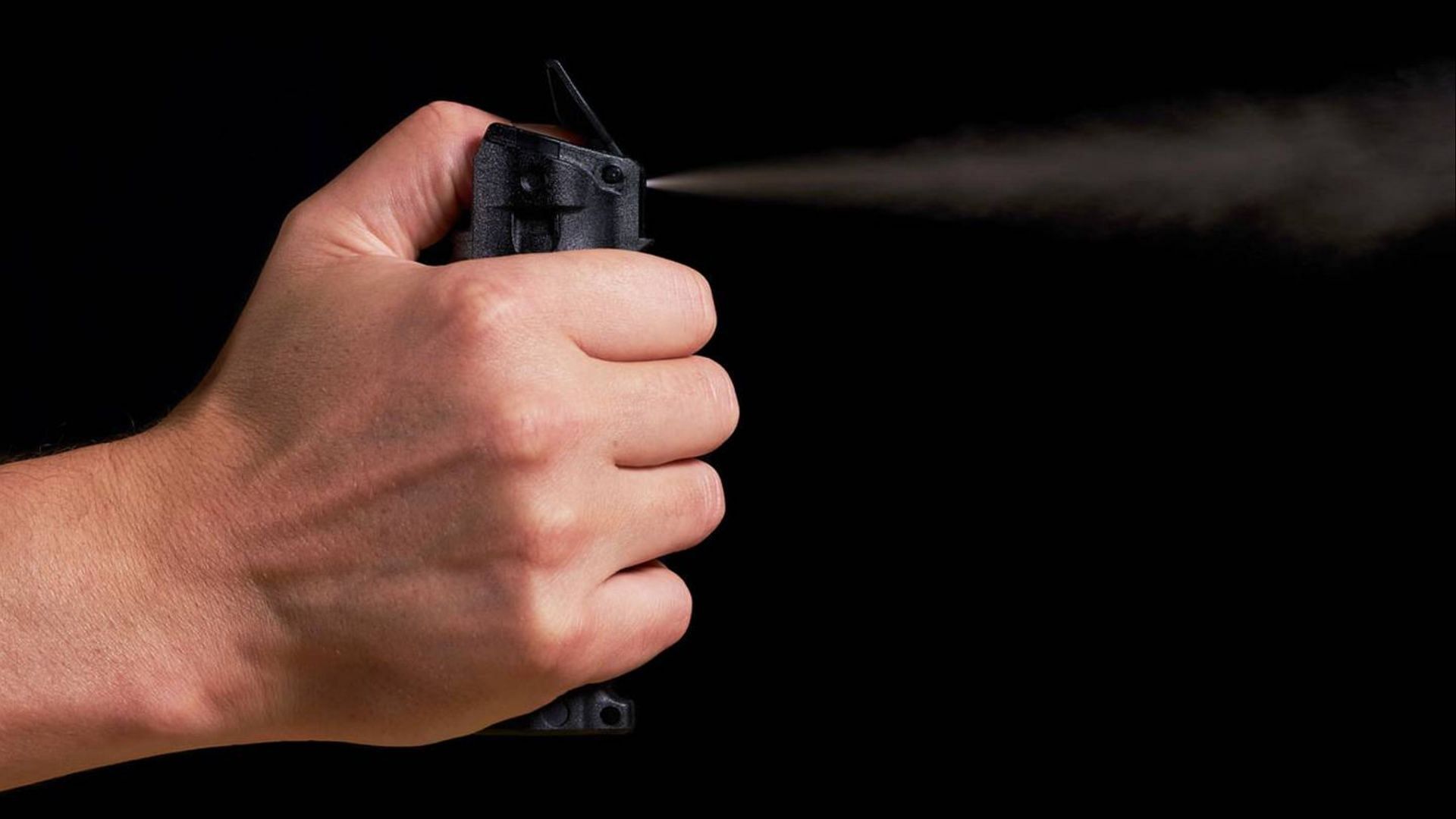 Police sprays mace on a group of women to break up their fight. (Image via Shutterstock)