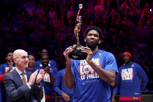 Joel Embiid lifting up the Michael Jordan MVP trophy.