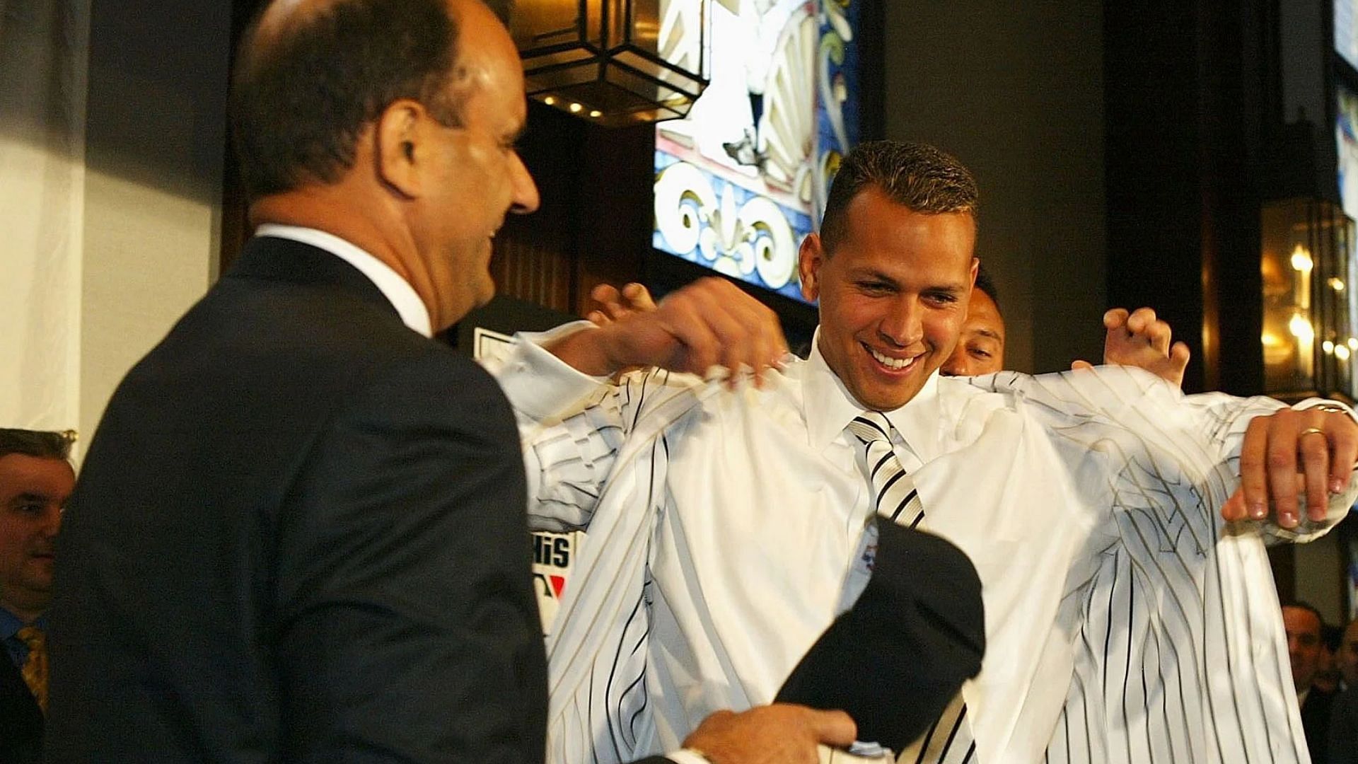 NEW YORK - FEBRUARY 17: Manager Joe Torre (L) and Derek Jeter help Alex Rodriguez (C) put on his pin strips at a press conference that announced Rodriguez as the newest New York Yankee on February 17, 2004 at Yankee Stadium in the Bronx, New York. (Photo by Ezra Shaw/Getty Images)