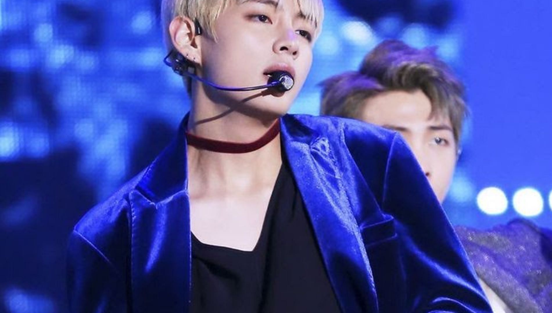 Taehyung in a blue velvet jacket and red choker (Image via. Koreaboo)