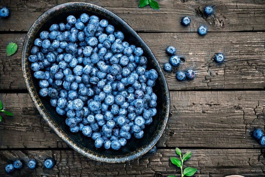 Organic wild blueberries on dark wooden background
