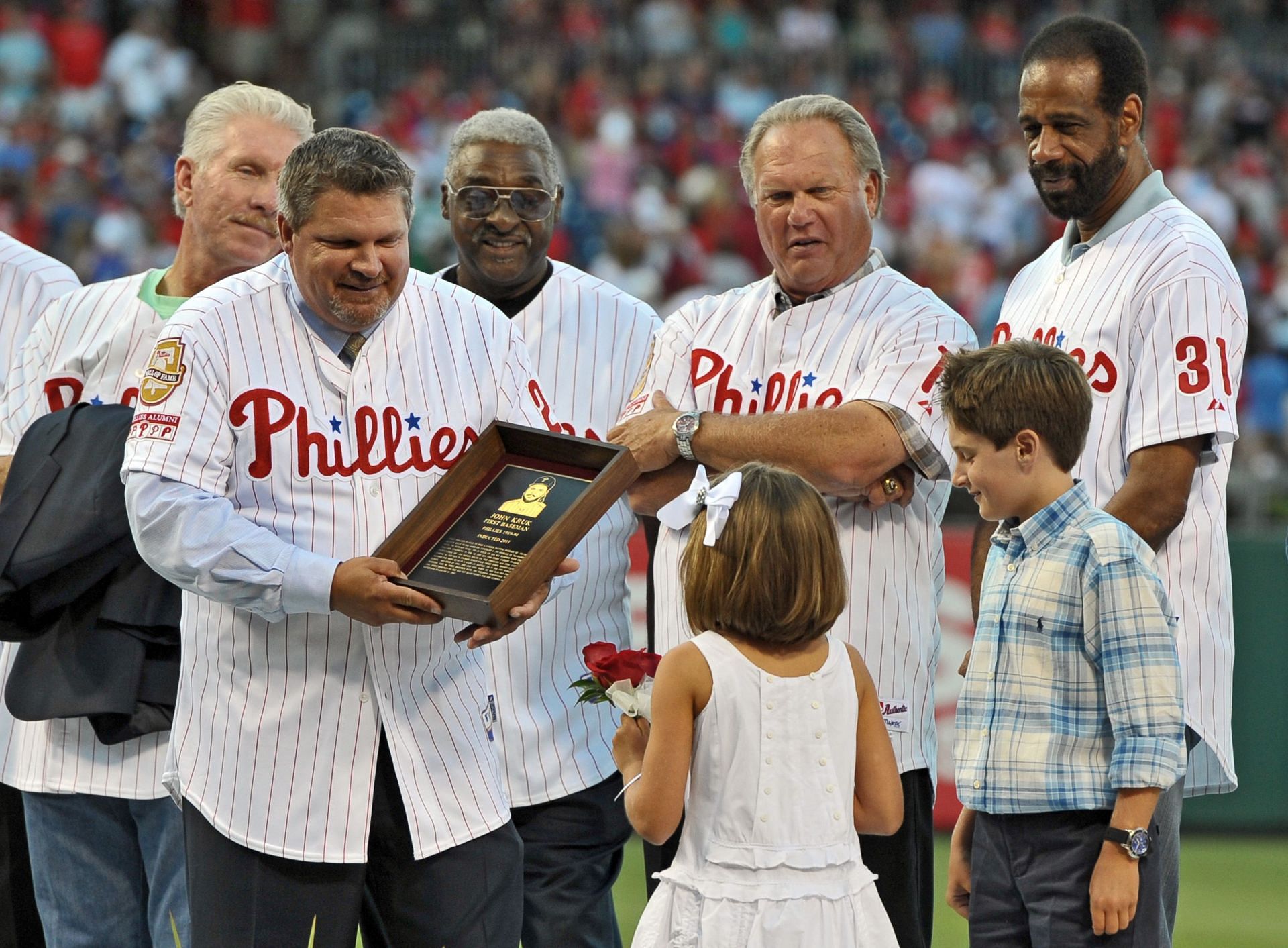 Philadelphia Phillies Wall of Fame inductee John Kruk is presented a plaque by his children Kiera (L) and Kyle (R) at Citizens Bank Park