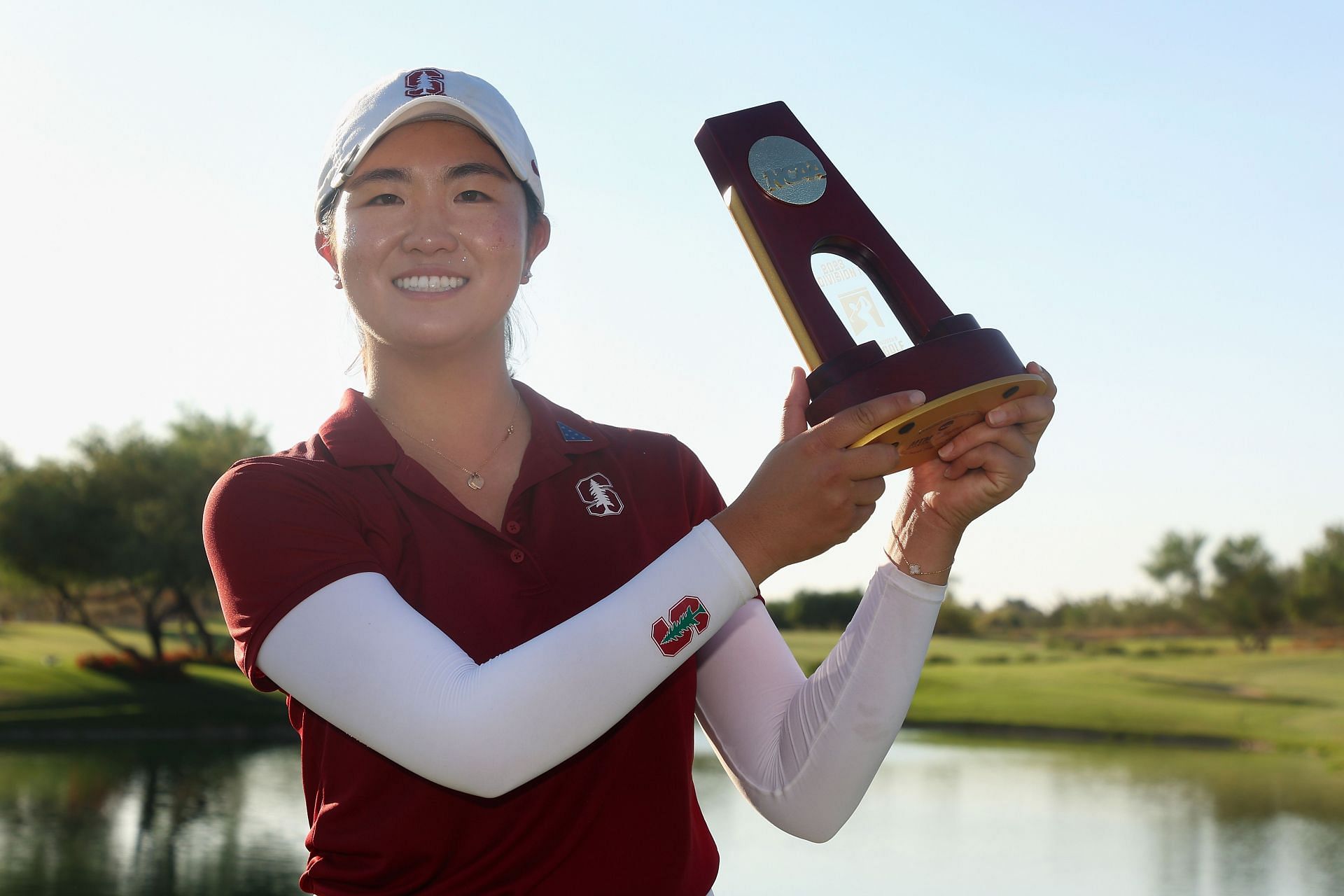 Rose Zhang posing with the NCAA Women&rsquo;s Golf Division One Championships trophy