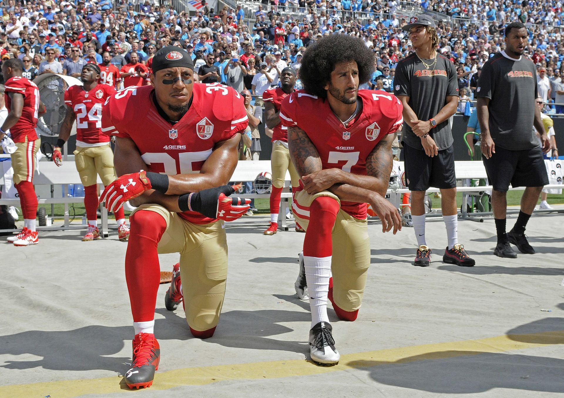 Colin Kaepernick and Eric Reid protest during the national anthem before an NFL game.