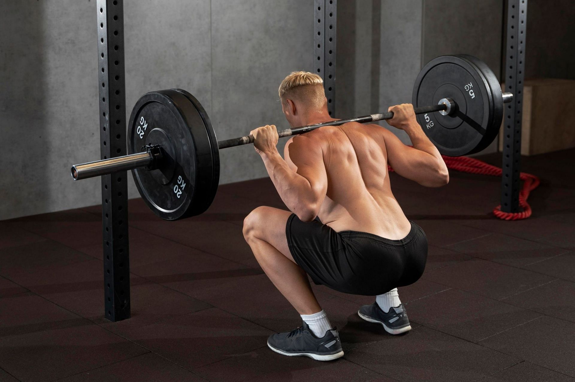 Barbell back squats are a great strength training exercise for fat loss. (Image via Freepik)