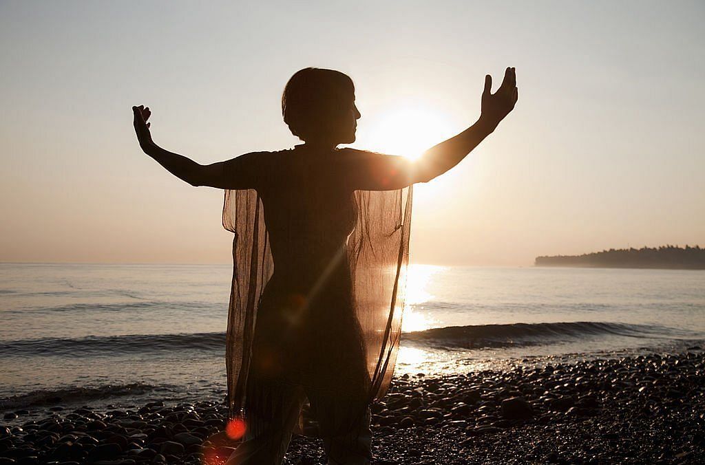 Senior woman practicing Qigong at sunrise 